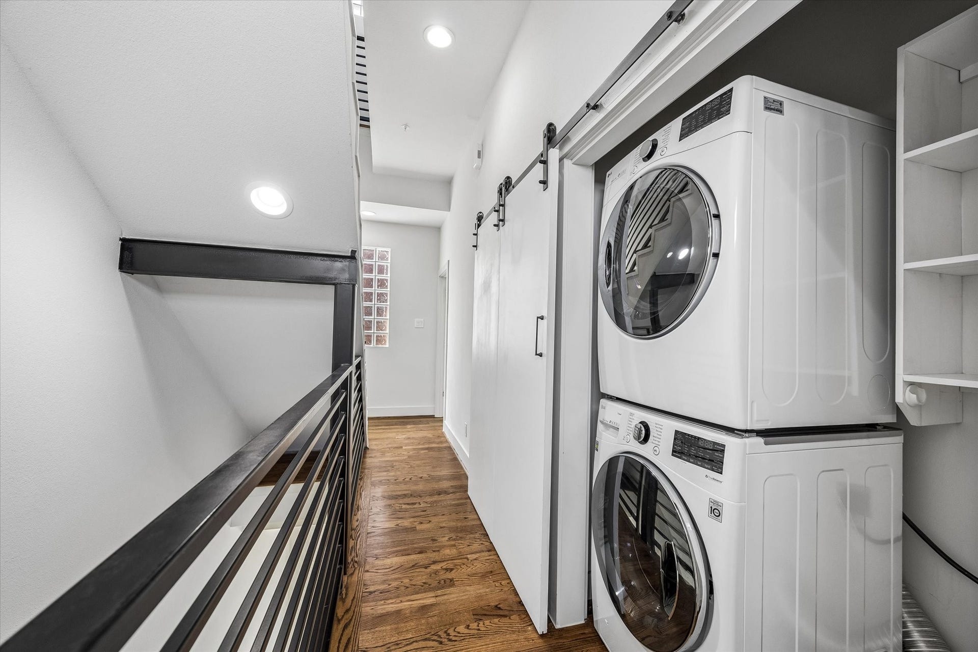 1215 Summer Street, #A, Houston, TX 77007 Laundry closet accommodates a stacked washer and dryer, with built-in shelving for storage. Sliding doors provide convenient access from the hallway.