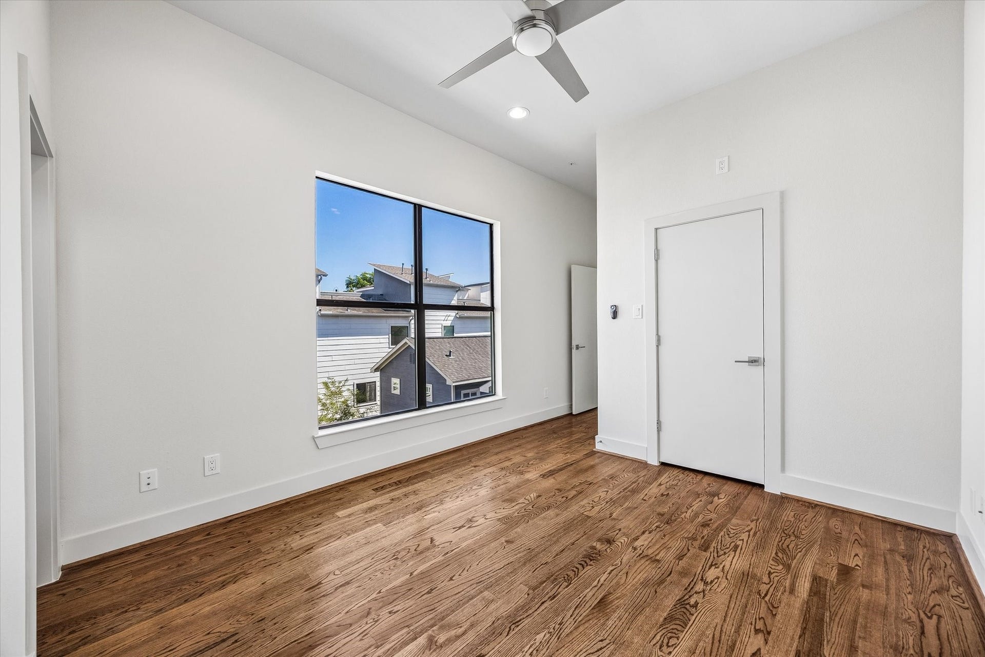 1215 Summer Street, #A, Houston, TX 77007 Secondary bedroom located on the third floor. Bright bedroom featuring an oversized window, wood flooring, high ceilings, recessed lighting, and a ceiling fan.