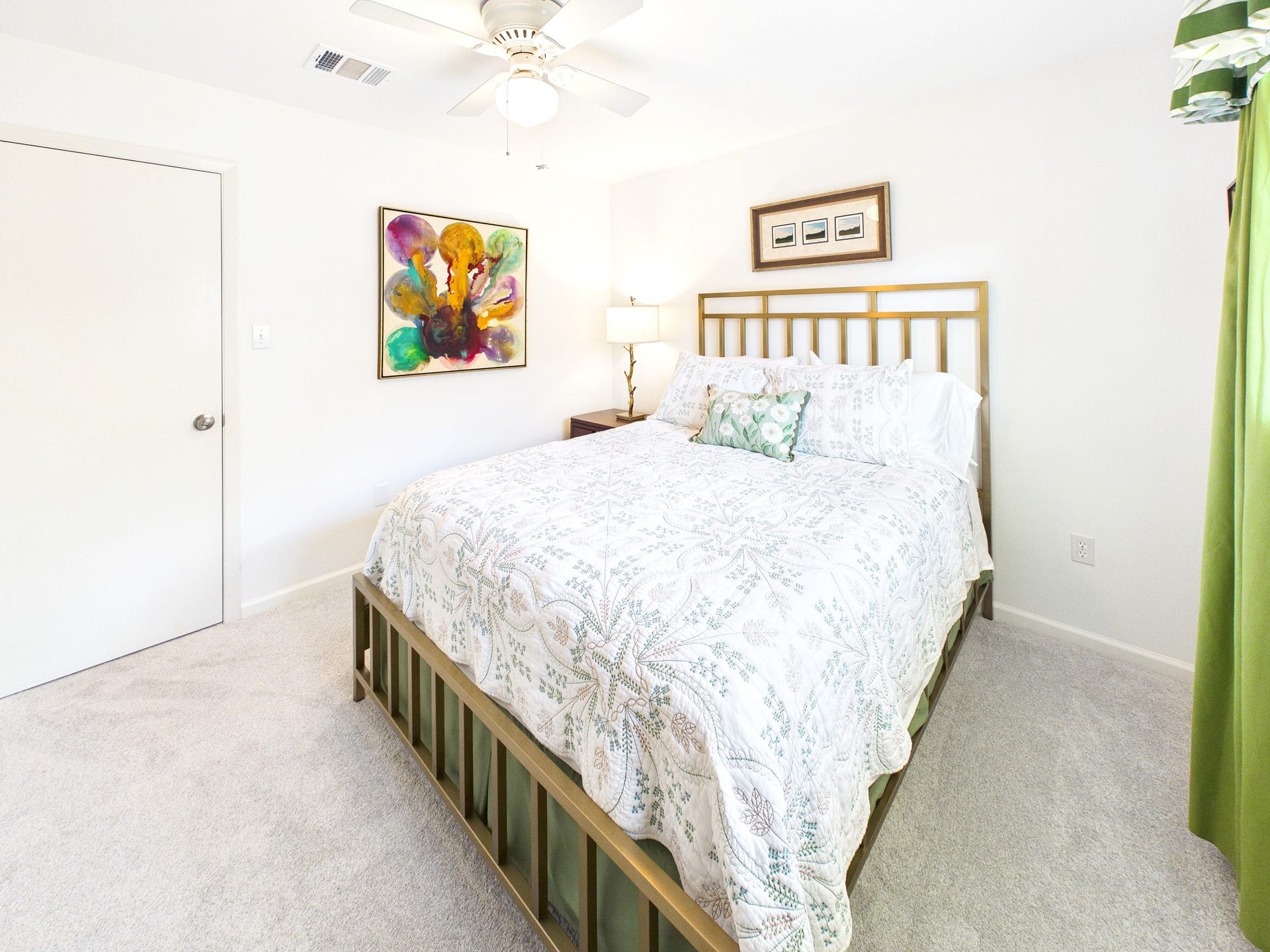 Bright and inviting, the second guest room offers comfort with a stylish bed, vibrant artwork, and a serene ambiance perfect for relaxation.