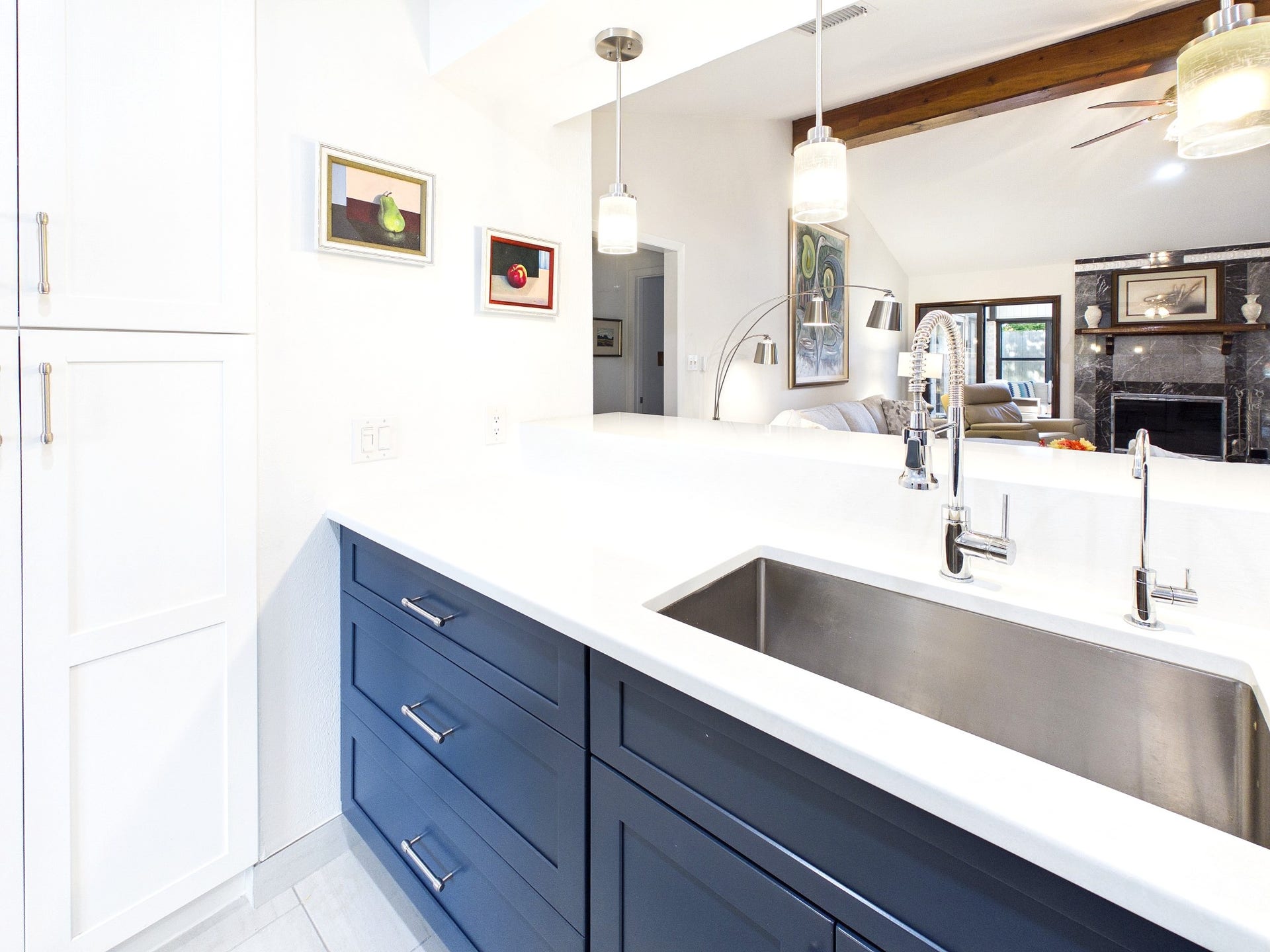 Discover the charm of a modern kitchen featuring a stunning farmhouse sink, complemented by sleek blue cabinetry and a bright, open layout perfect for entertaining.