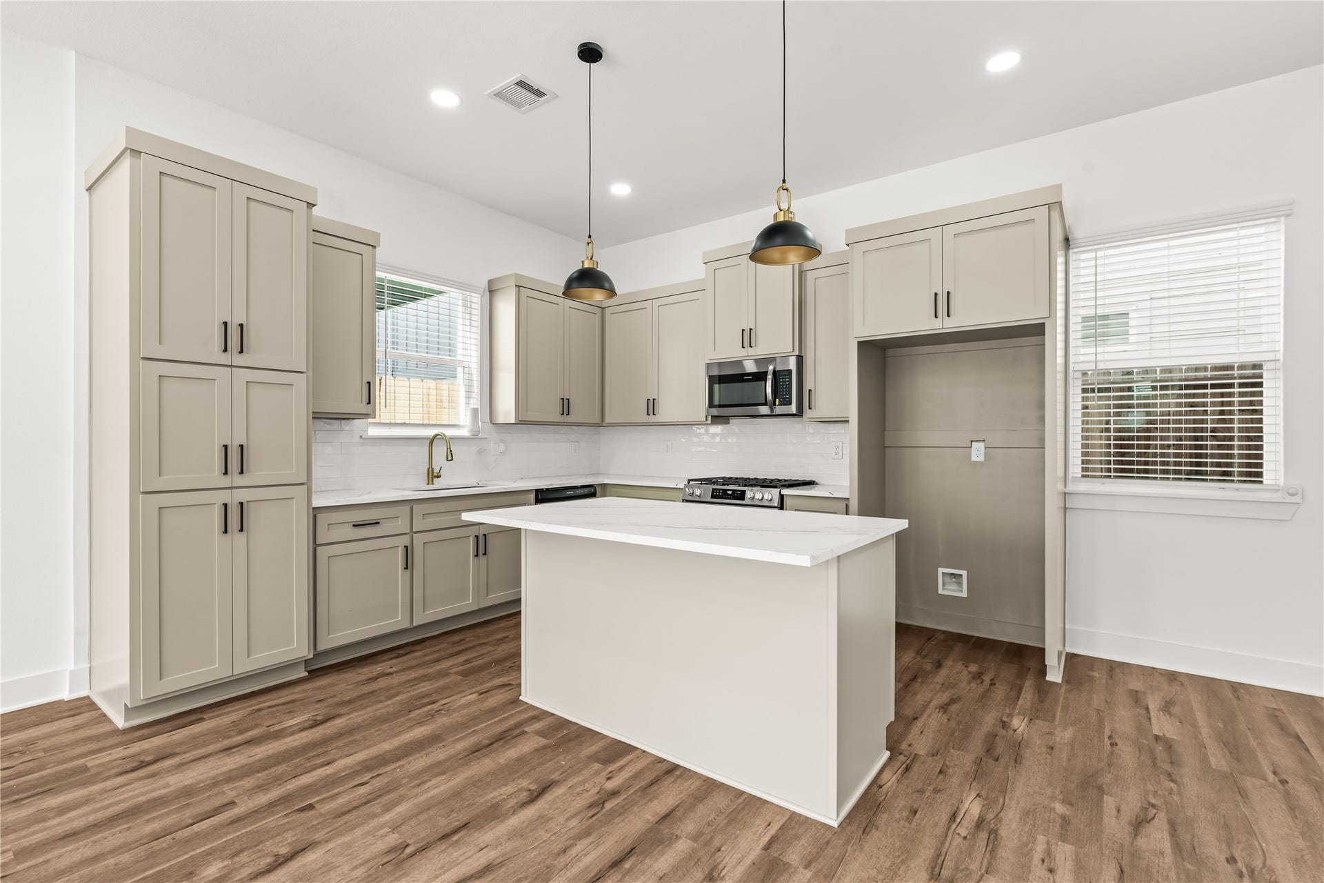 1912 Schweikhardt Street, Houston, TX 77020 Sophisticated and fully equipped. High-end built-in appliances, a classic subway tile backsplash, and dramatic matte-black and gold pendant lights elevate your daily cooking experience.