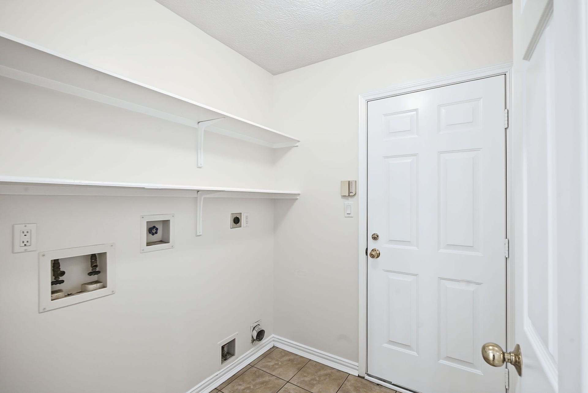 51 Pinery Ridge Place, The Woodlands, TX 77382 A dedicated laundry room includes washer and dryer connections, overhead shelving, and hanging space to simplify laundry day.