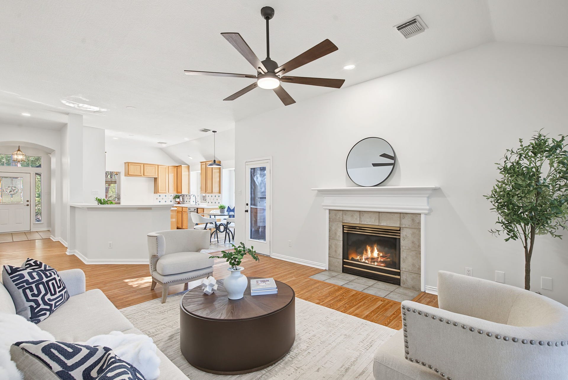 51 Pinery Ridge Place, The Woodlands, TX 77382 The fireplace anchors the living room, while the kitchen pass-through keeps conversation flowing between the main gathering spaces.