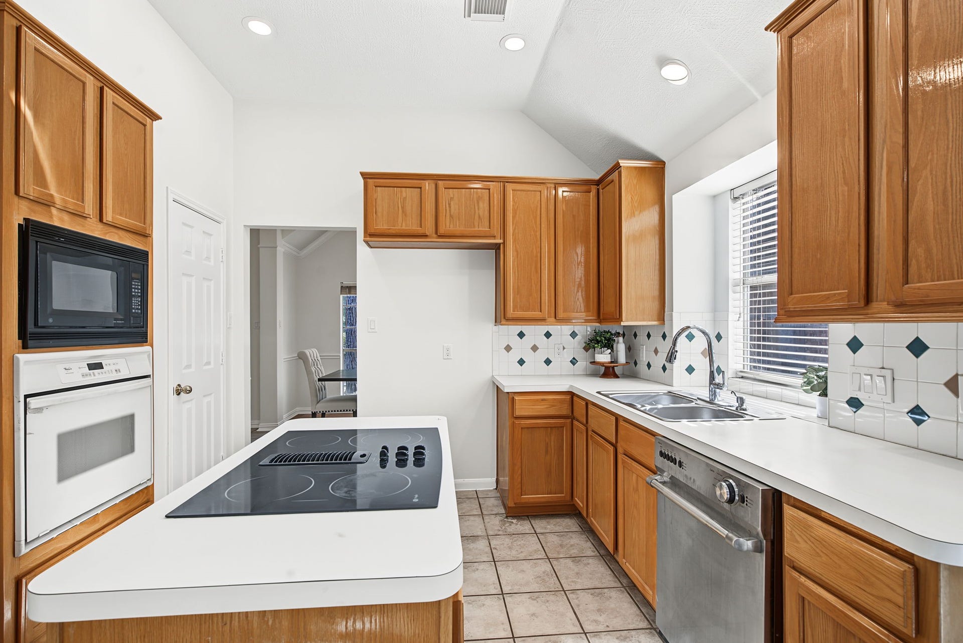 51 Pinery Ridge Place, The Woodlands, TX 77382 The island cooktop and built-in oven and microwave keep cooking functions organized, with surrounding cabinets providing plentiful storage.