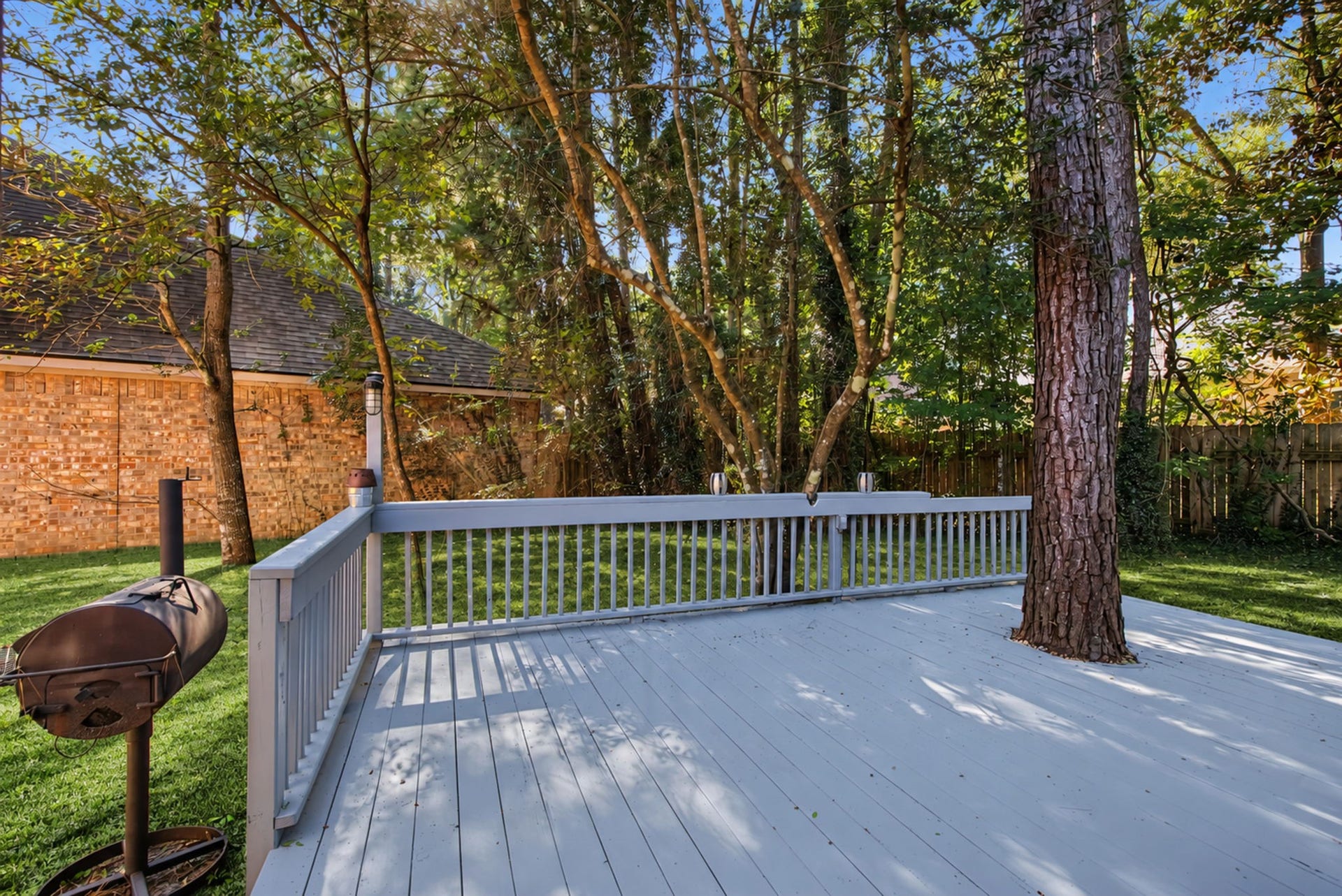 51 Pinery Ridge Place, The Woodlands, TX 77382 The freshly recoated rear deck extends your living space outdoors, with room to arrange seating beneath the mature trees.