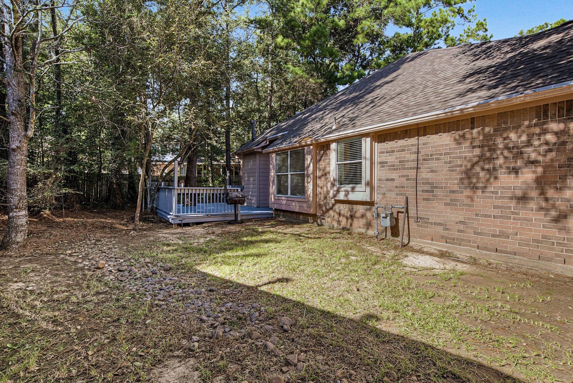 51 Pinery Ridge Place, The Woodlands, TX 77382 The side yard extends alongside the brick exterior and connects to the rear deck, providing another usable stretch of outdoor space.