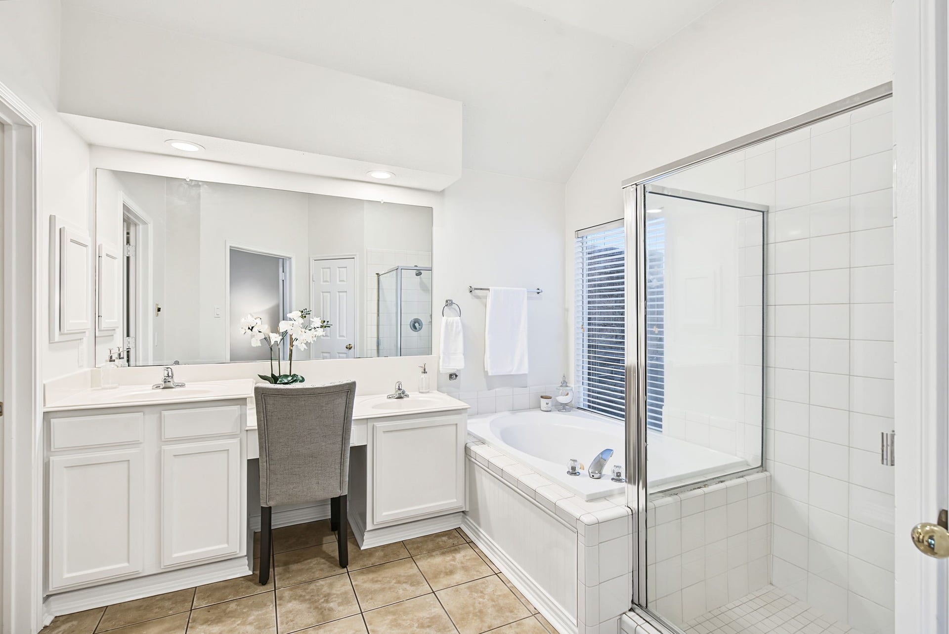 51 Pinery Ridge Place, The Woodlands, TX 77382 A wide mirror and dual-sink vanity complement the primary bathrooms separate tub and shower, offering room to personalize the finishes over time.