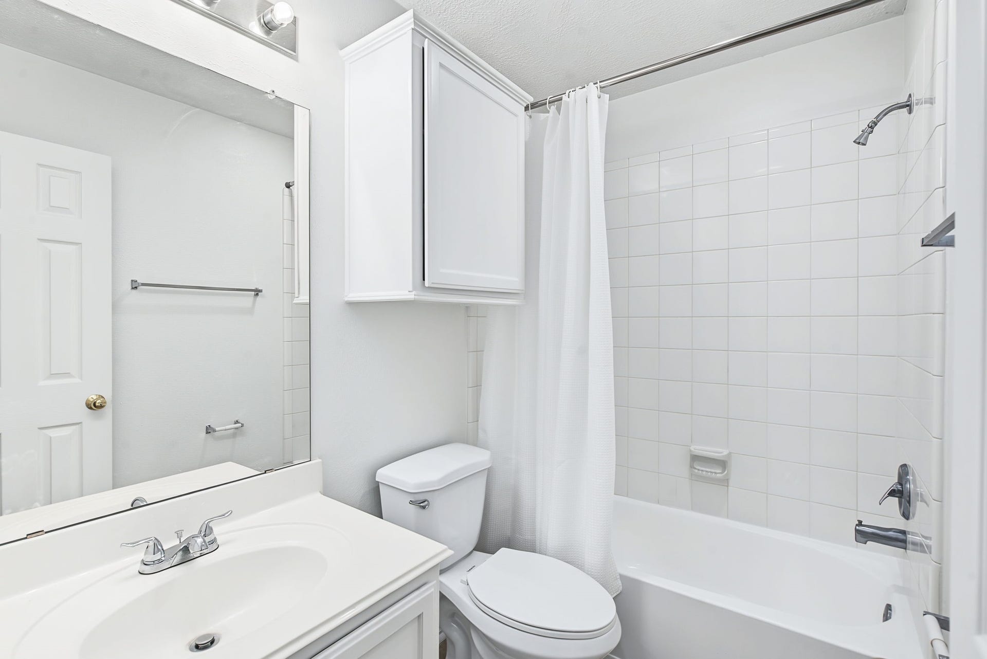 51 Pinery Ridge Place, The Woodlands, TX 77382 The refreshed guest bathroom features a white vanity, additional wall storage, and a tub-and-shower combination.