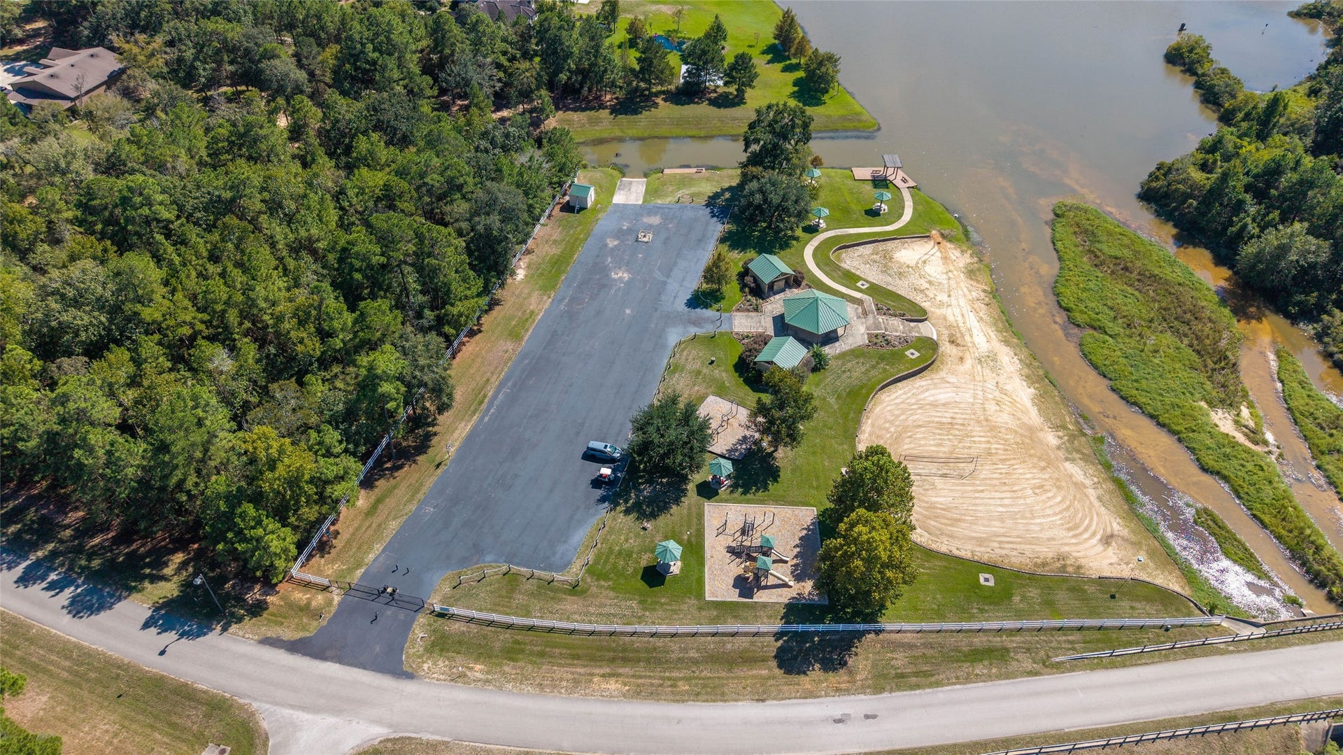 0 Ridgelake Court, Montgomery, TX 77316 Serene lakeside property with lush greenery, a spacious playground, and a covered pavilion, perfect gatherings and outdoor enjoyment.