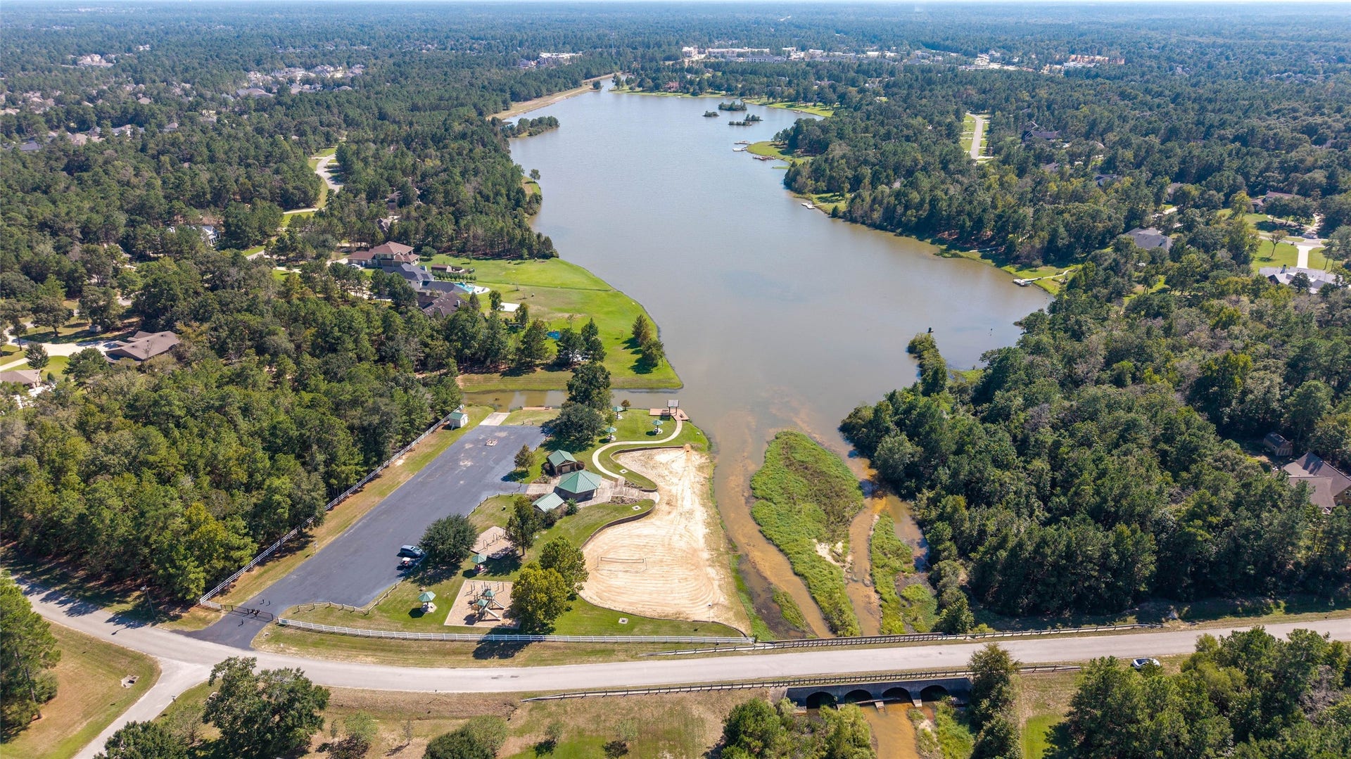 0 Ridgelake Court, Montgomery, TX 77316 Stunning aerial view of a serene lakeside community surrounded by lush greenery, offering peaceful living with recreational amenities and scenic landscapes.