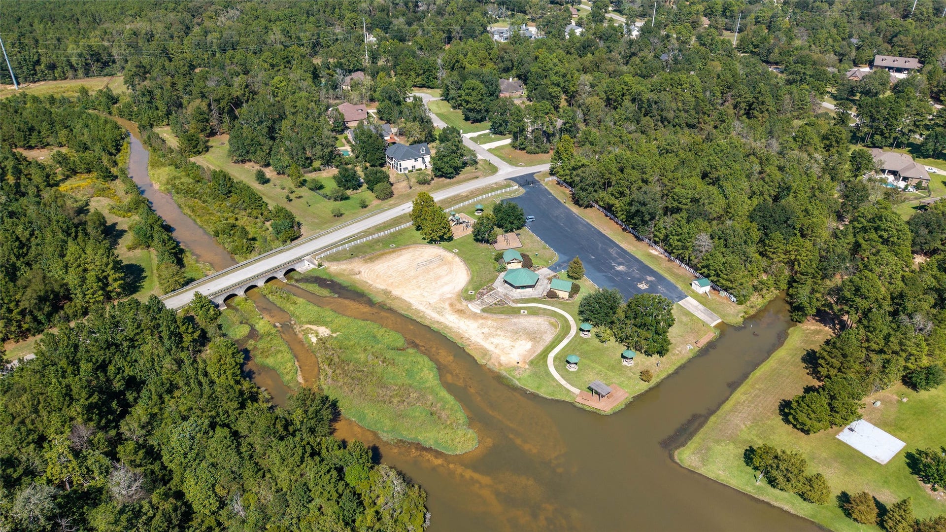 0 Ridgelake Court, Montgomery, TX 77316 Expansive aerial view showcasing a serene lakeside community, surrounded by lush greenery and winding waterways, offering a blend of tranquility and natural beauty.