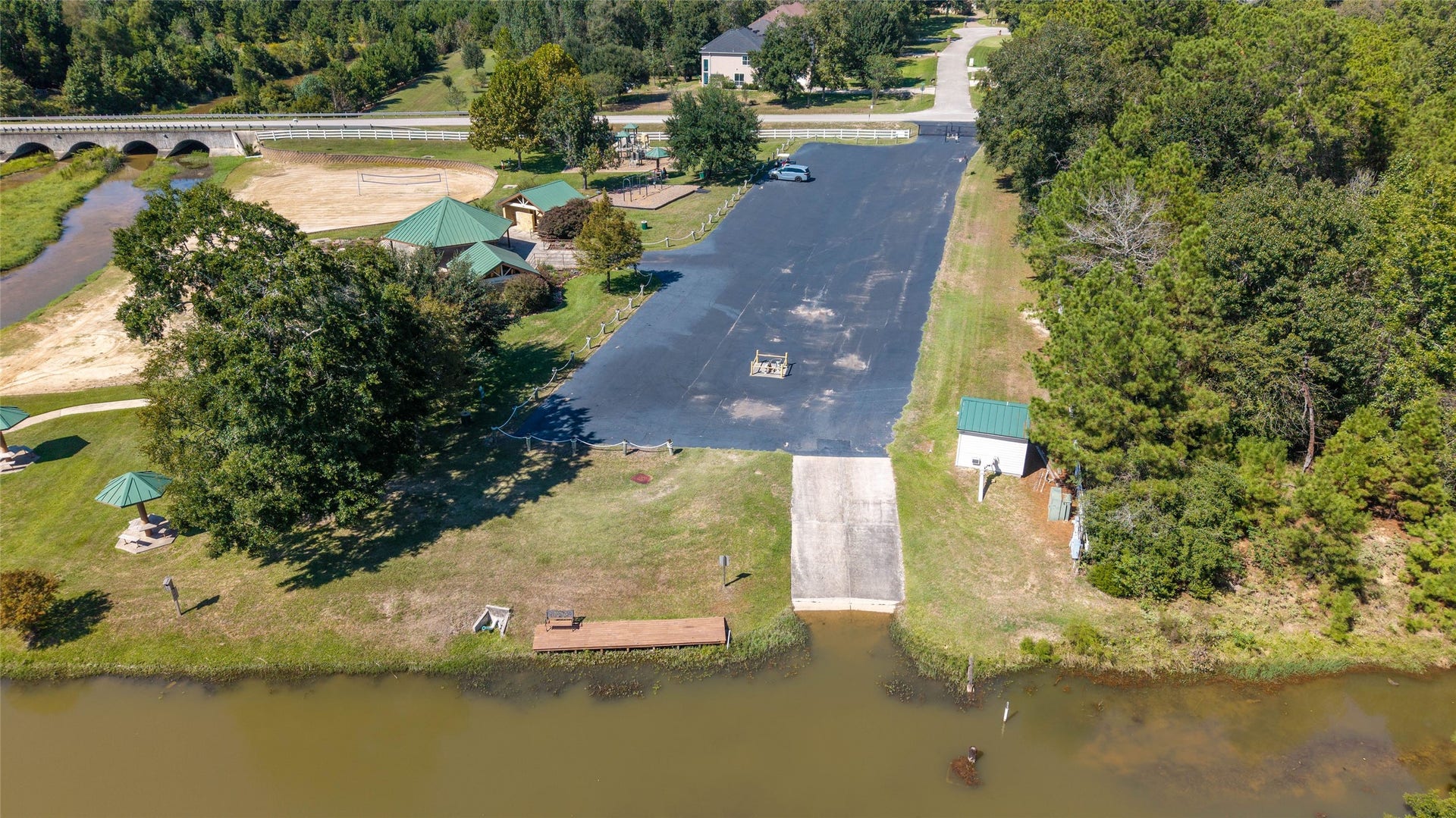 0 Ridgelake Court, Montgomery, TX 77316 Beautifully situated by a serene waterfront, this property features a spacious paved area with lush greenery, picnic pavilions, and convenient boat ramp access, perfect for outdoor enthusiasts.