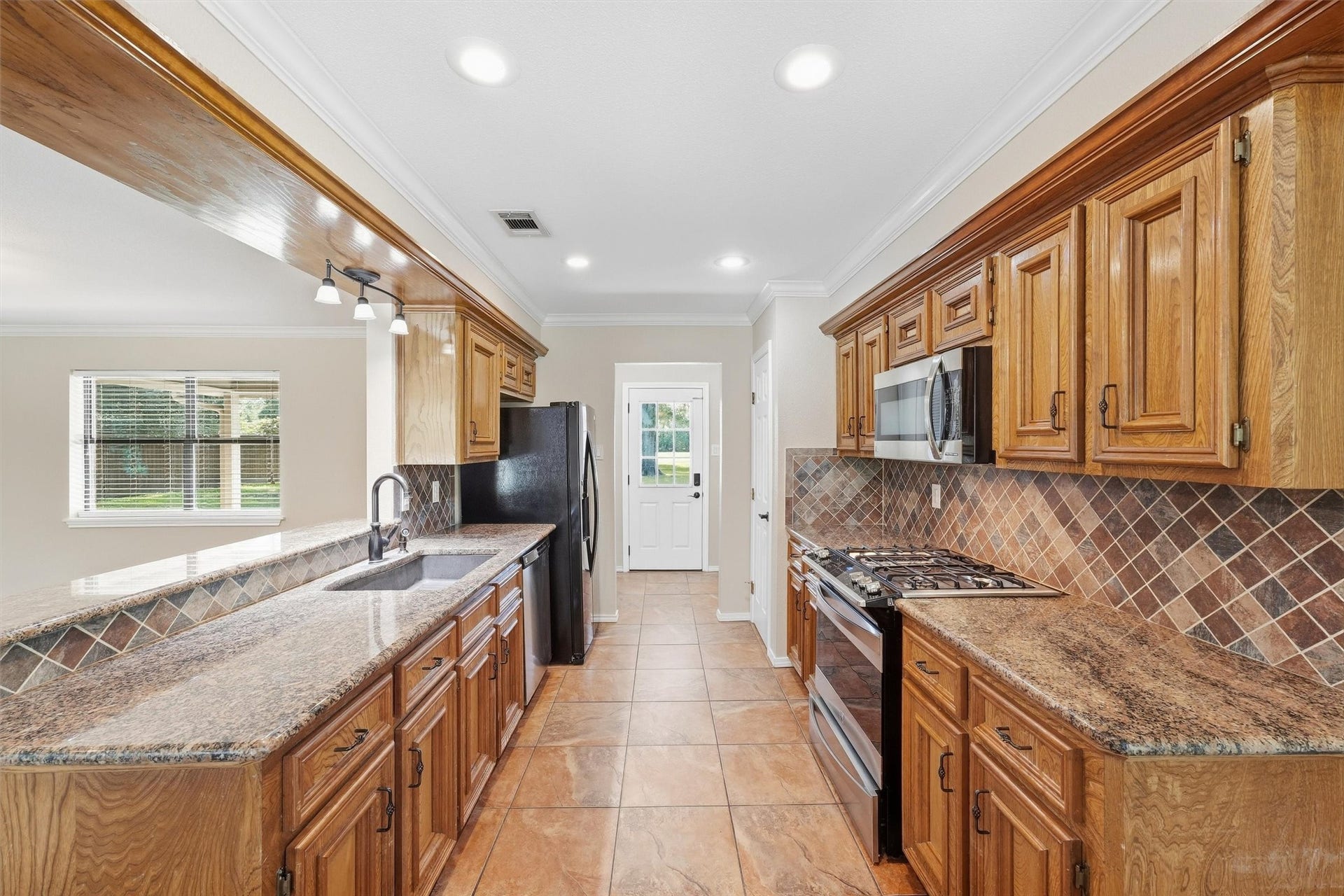7321 Root Road, Spring, TX 77389 Beautiful gourmet kitchen w/solid wood cabinetry, granite countertops, tile backsplash & stainless appliances.