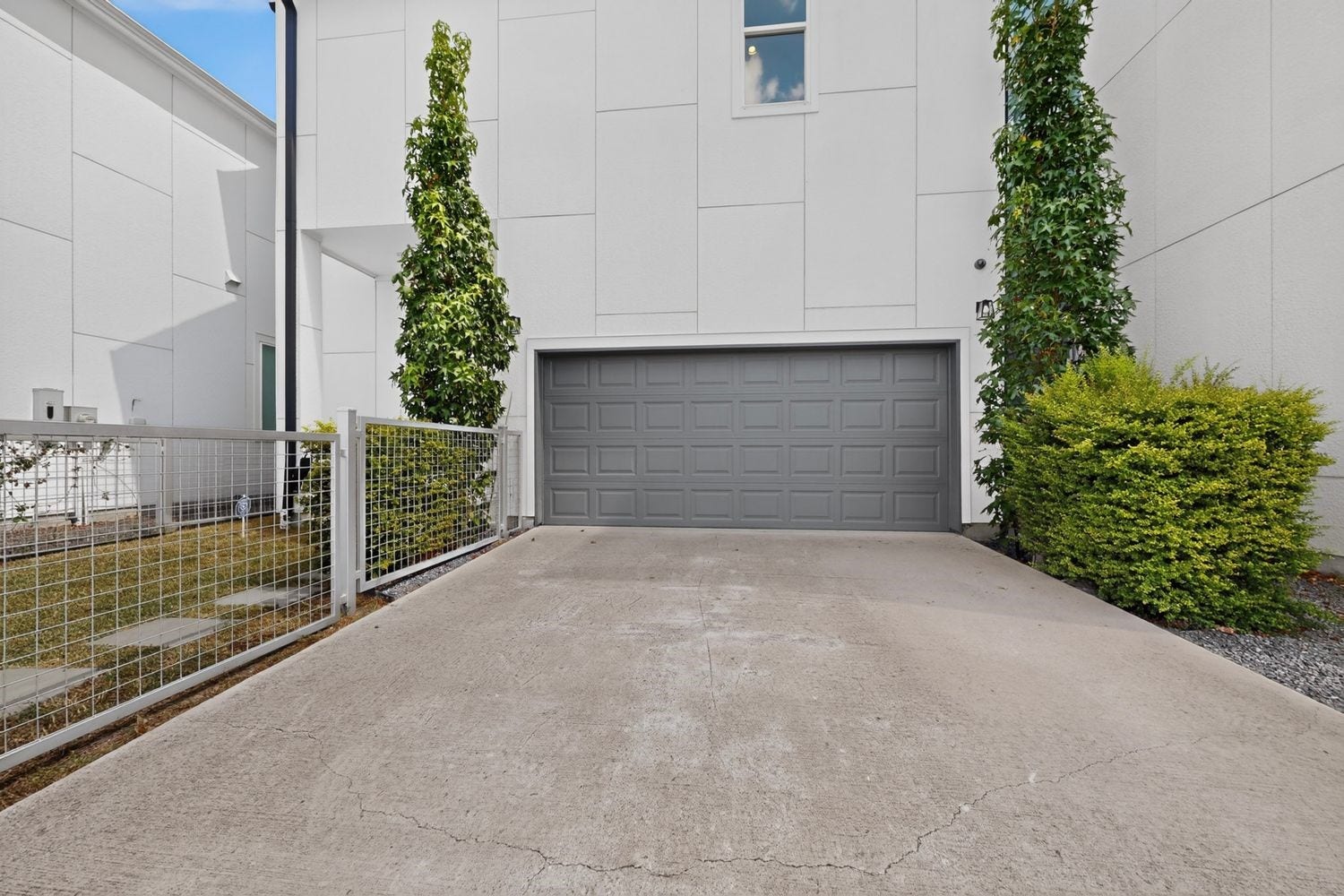 9820 Mocking Bird Hill Lane, Houston, TX 77080 And from the rear you have your Two-car garage framed by lush greenery and your private double wide driveway, offering a clean and easy and contemporary entrance.