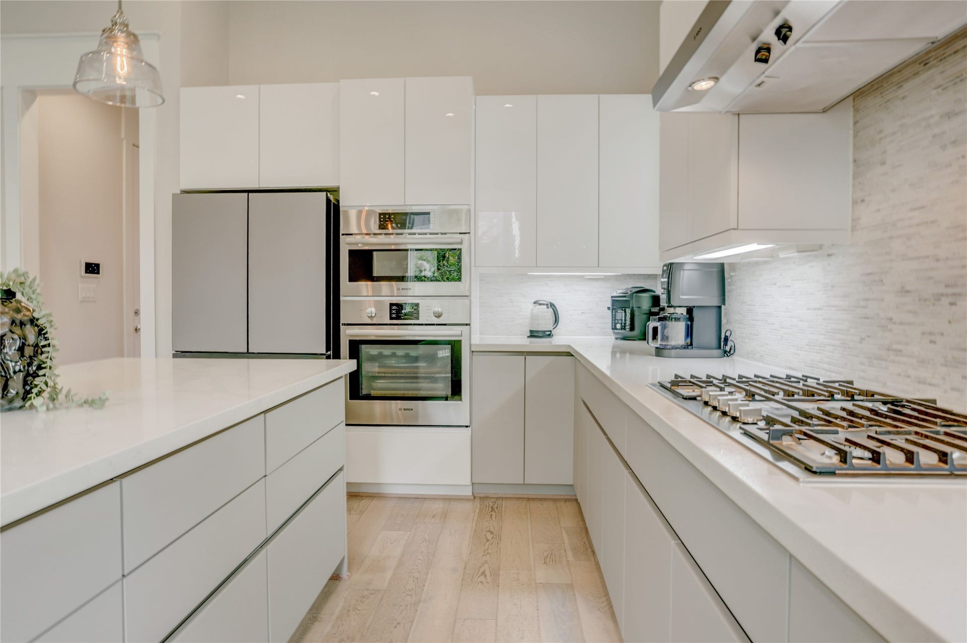 9820 Mocking Bird Hill Lane, Houston, TX 77080 Sleek modern kitchen with high-gloss cabinetry, stainless steel appliances, and a spacious island.