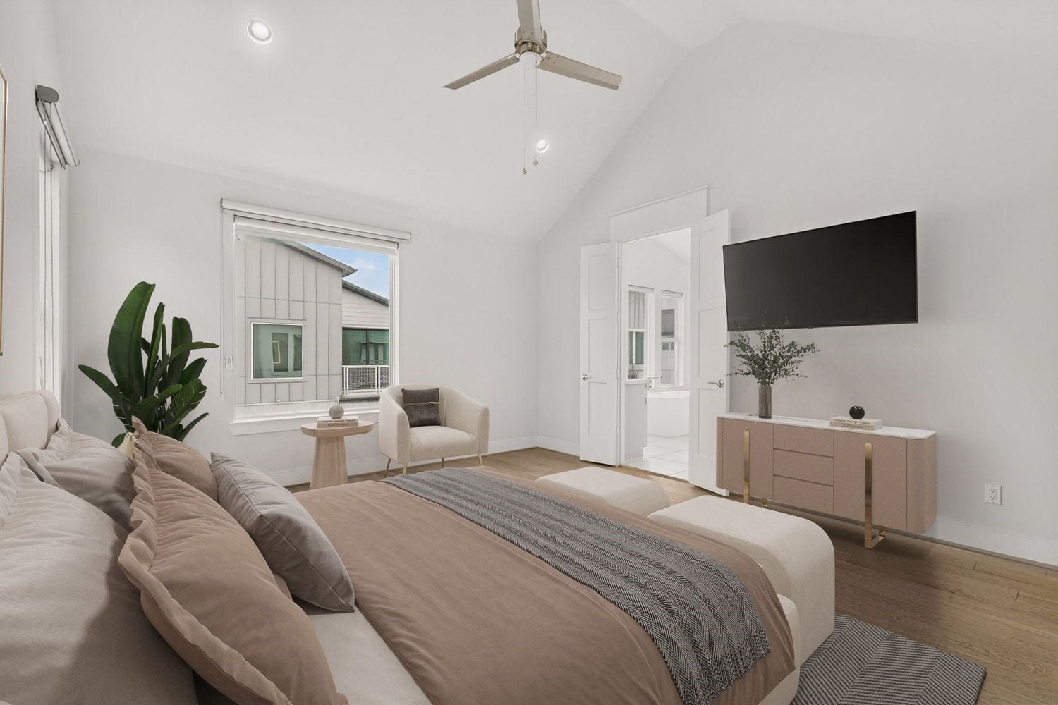 9820 Mocking Bird Hill Lane, Houston, TX 77080 Another look a the modern comfort in this bright, spacious Primary bedroom featuring vaulted ceilings, elegant hardwood floors, and a sleek ceiling fan.