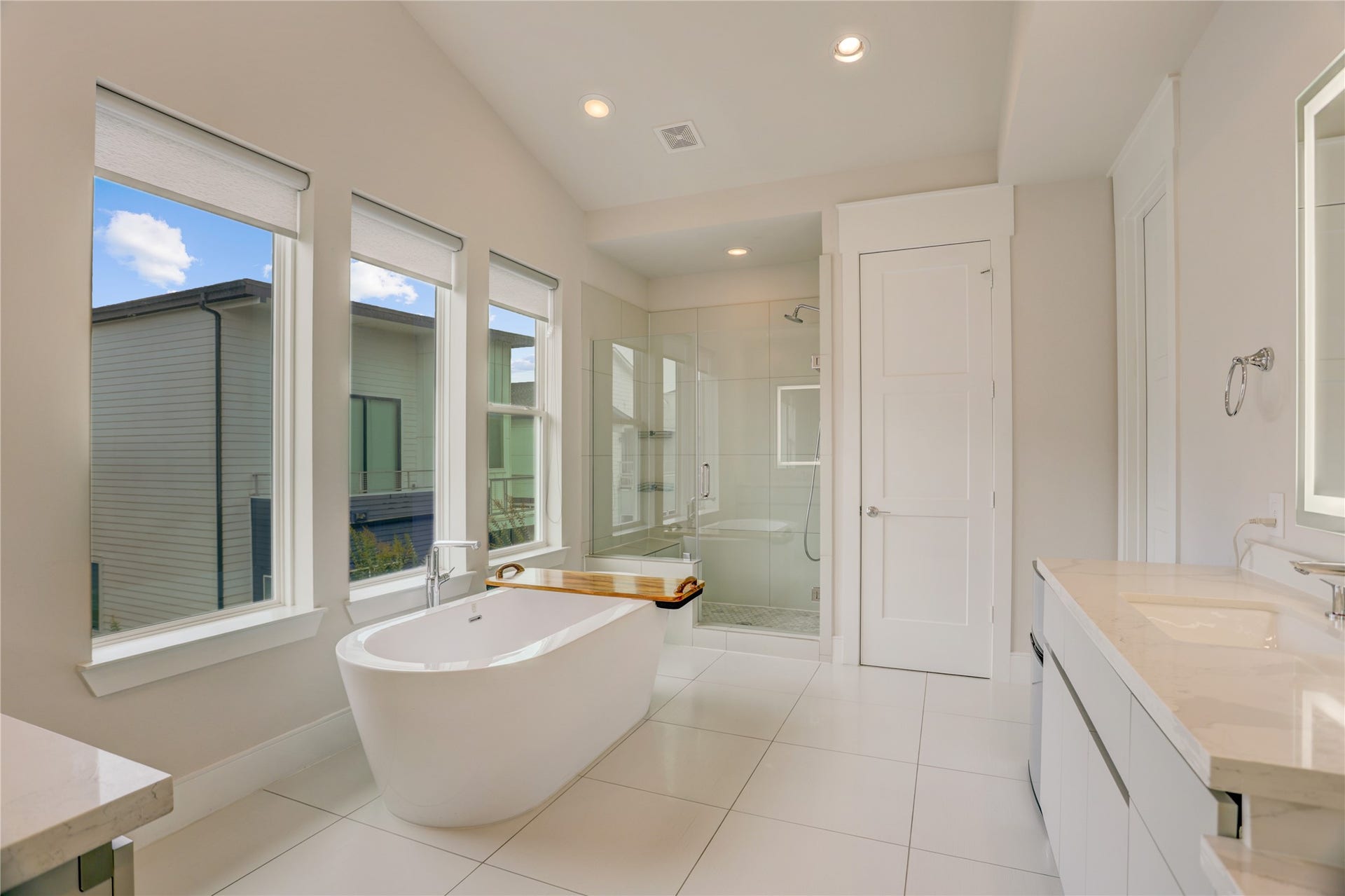 9820 Mocking Bird Hill Lane, Houston, TX 77080 Luxurious Primary bathroom featuring a freestanding tub, spacious glass-enclosed shower, and modern double vanity with ample natural light from large windows.