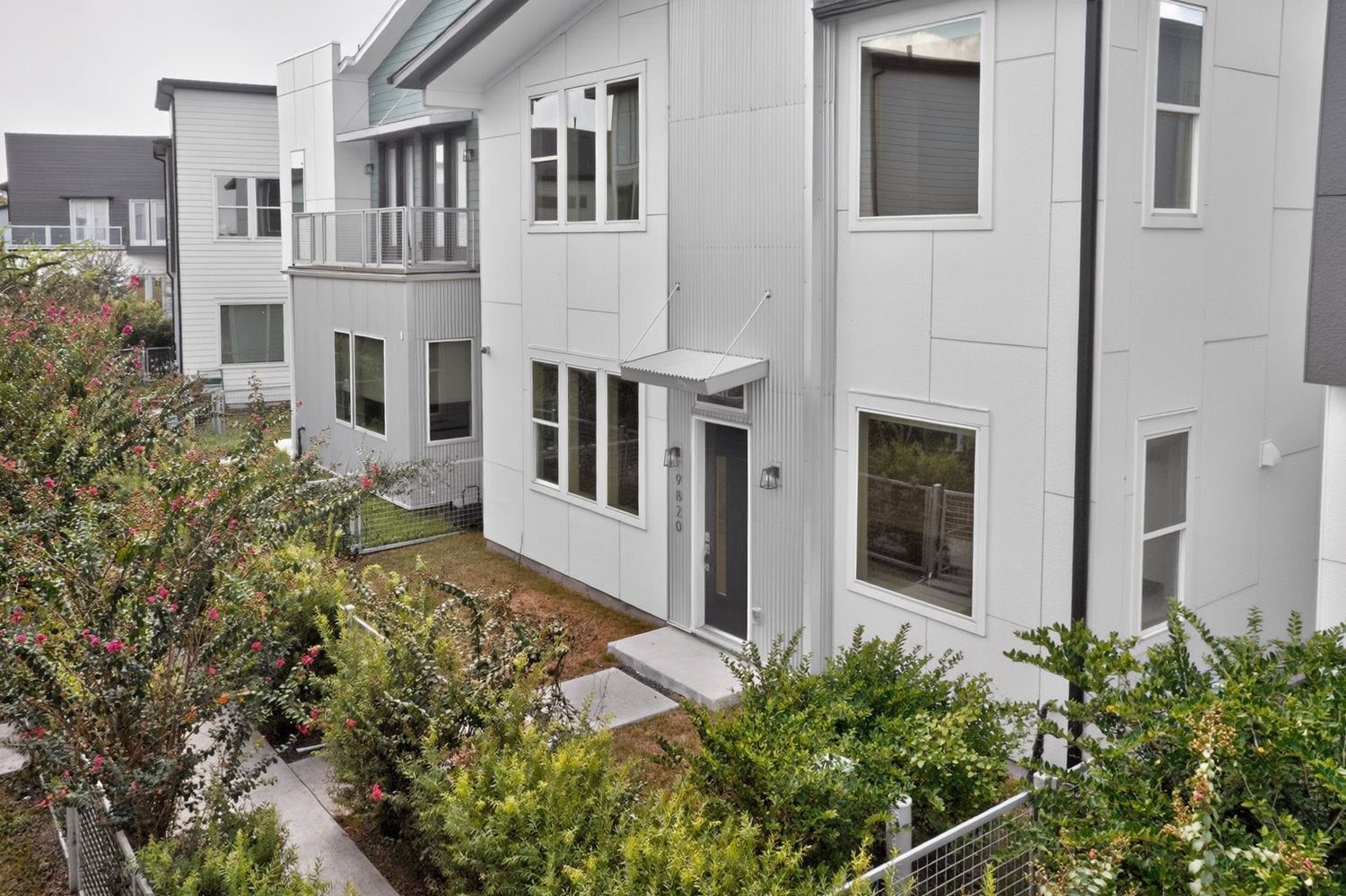 9820 Mocking Bird Hill Lane, Houston, TX 77080 Modern townhouse with sleek architecture, featuring large windows and a welcoming front entrance surrounded by lush greenery.