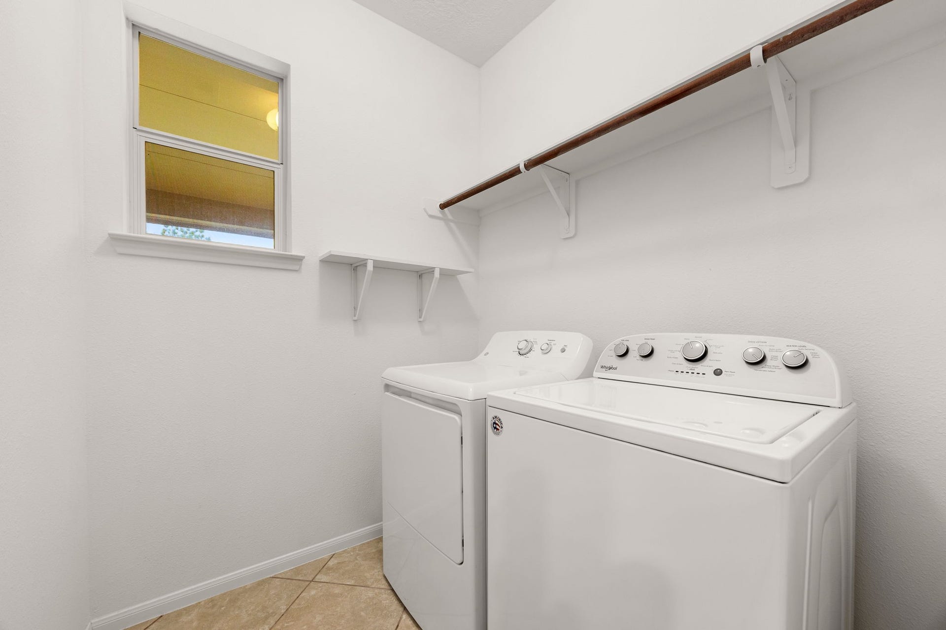 26311 Smokey Valley Lane, Katy, TX 77494 The utility room keeps chores simple, with electric dryer and washer connections, a built-in shelf, a hanging rod, and a window for natural light.