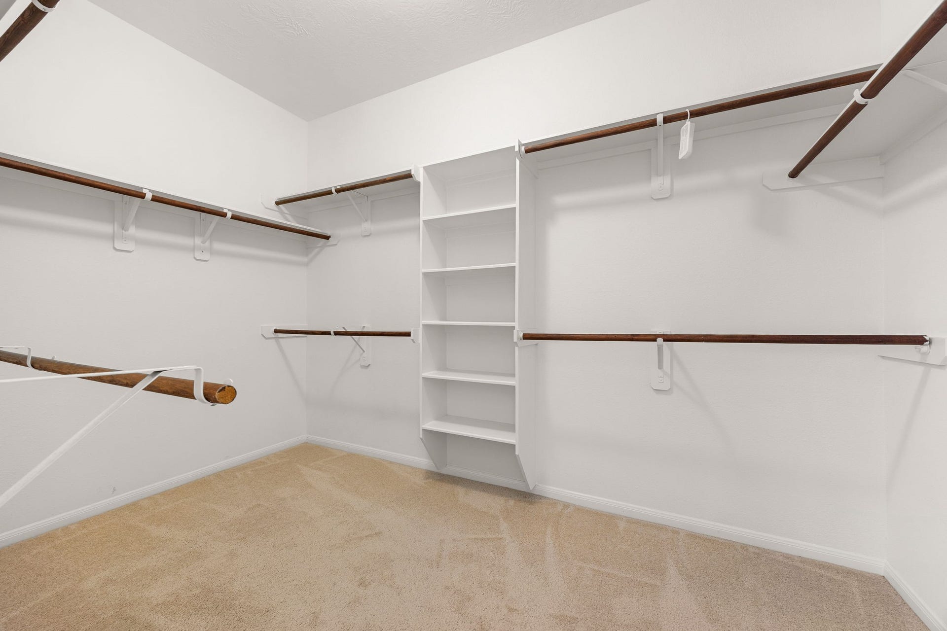 26311 Smokey Valley Lane, Katy, TX 77494 The generous walk-in closet keeps everything organized with a built-in shelving tower and double hanging rods along multiple walls.