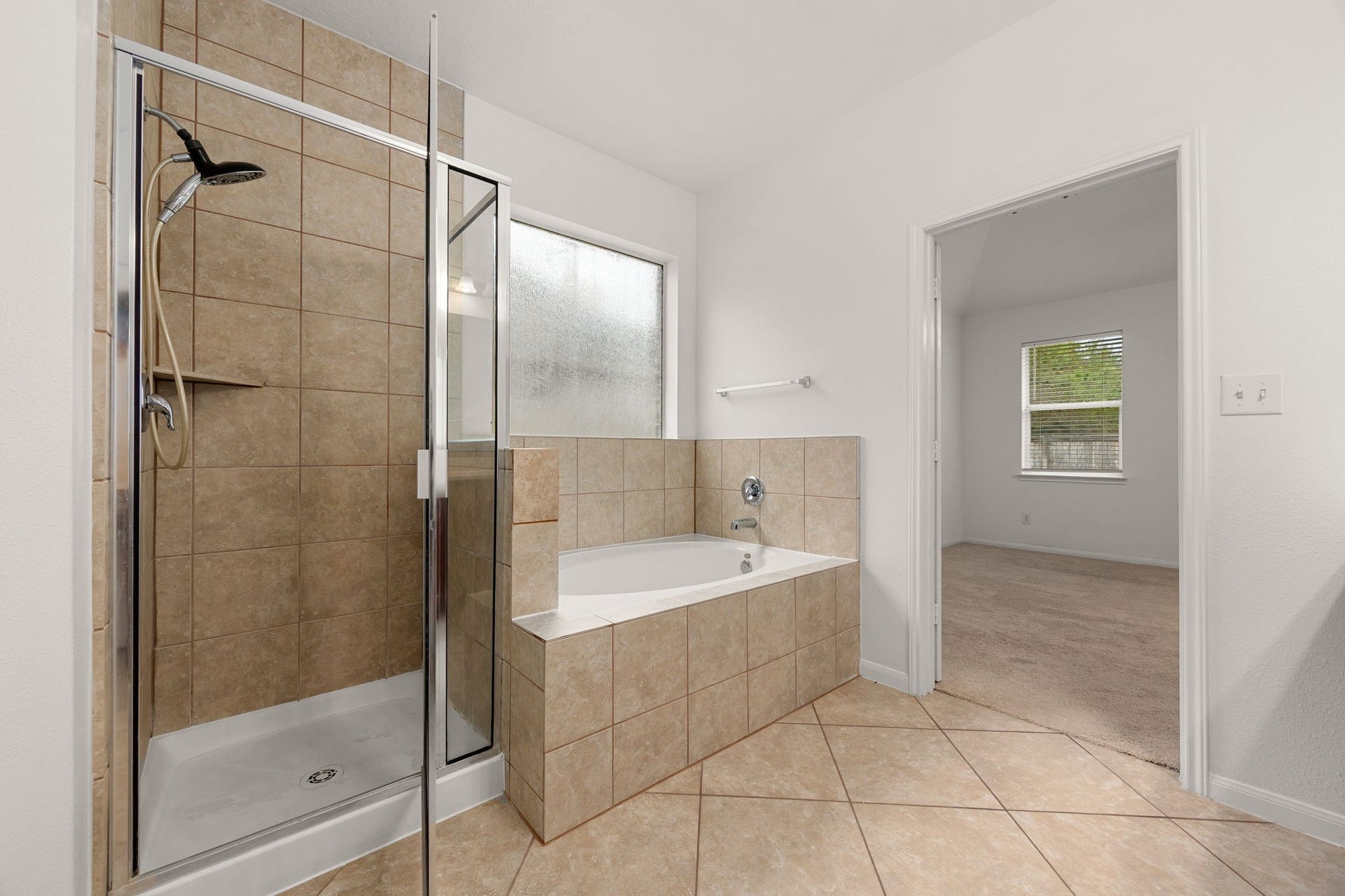 26311 Smokey Valley Lane, Katy, TX 77494 Unwind in the tile-surround soaking tub beneath a frosted privacy window, or step into the separate glass-enclosed shower with a handheld showerhead.