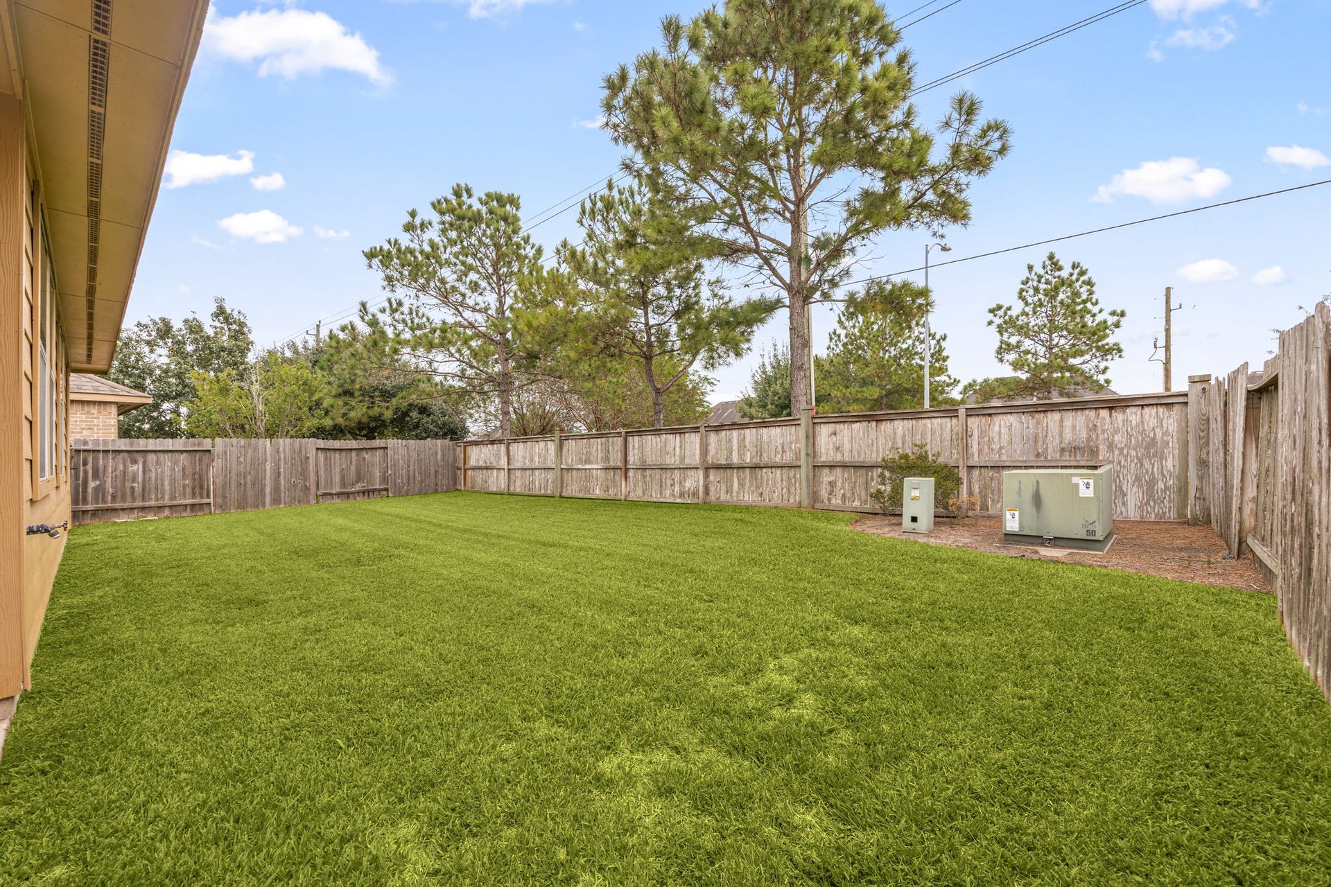26311 Smokey Valley Lane, Katy, TX 77494 Tall pines rise along the back fence line, adding natural shade and a peaceful backdrop to the expansive, fully fenced lawn.