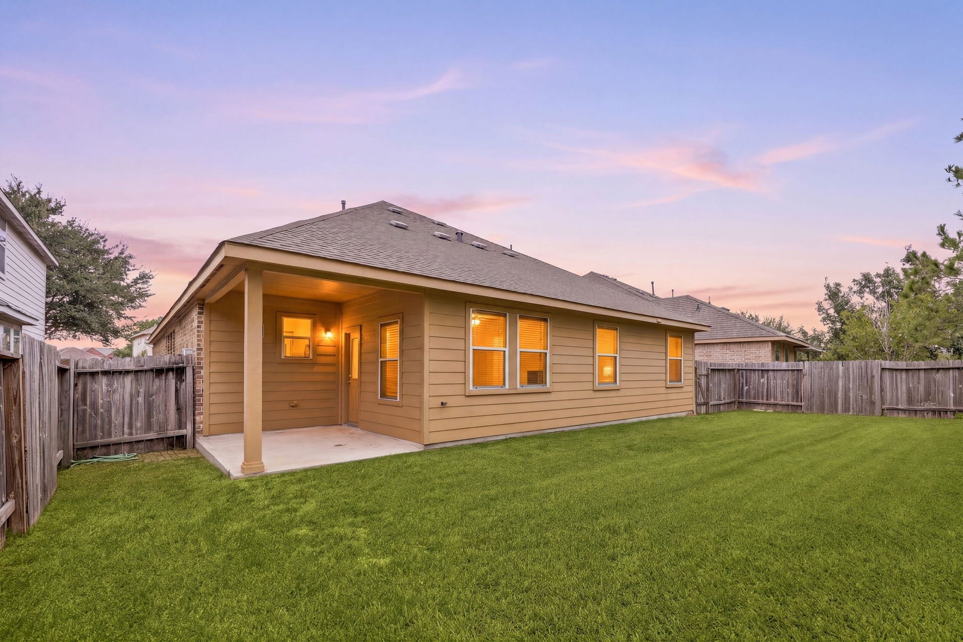 26311 Smokey Valley Lane, Katy, TX 77494 As evening falls, the covered patio opens onto a fully fenced backyard with a wide, level lawn. Its an inviting setting for outdoor dining and relaxing.