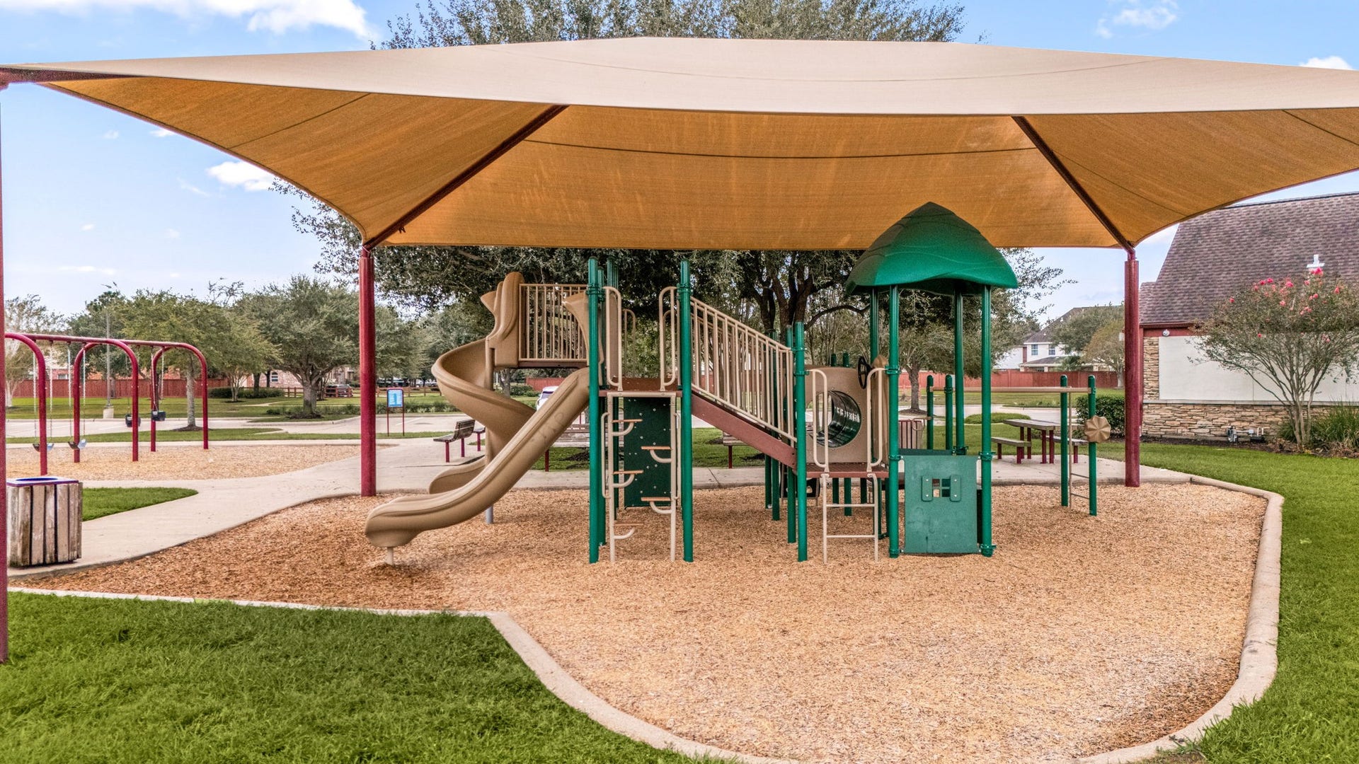26311 Smokey Valley Lane, Katy, TX 77494 Silver Ranchs neighborhood playground includes slides, climbing features, swings, and picnic tables for outdoor recreation. A large shade canopy covers the main play structure, providing added protection from the Texas sun.