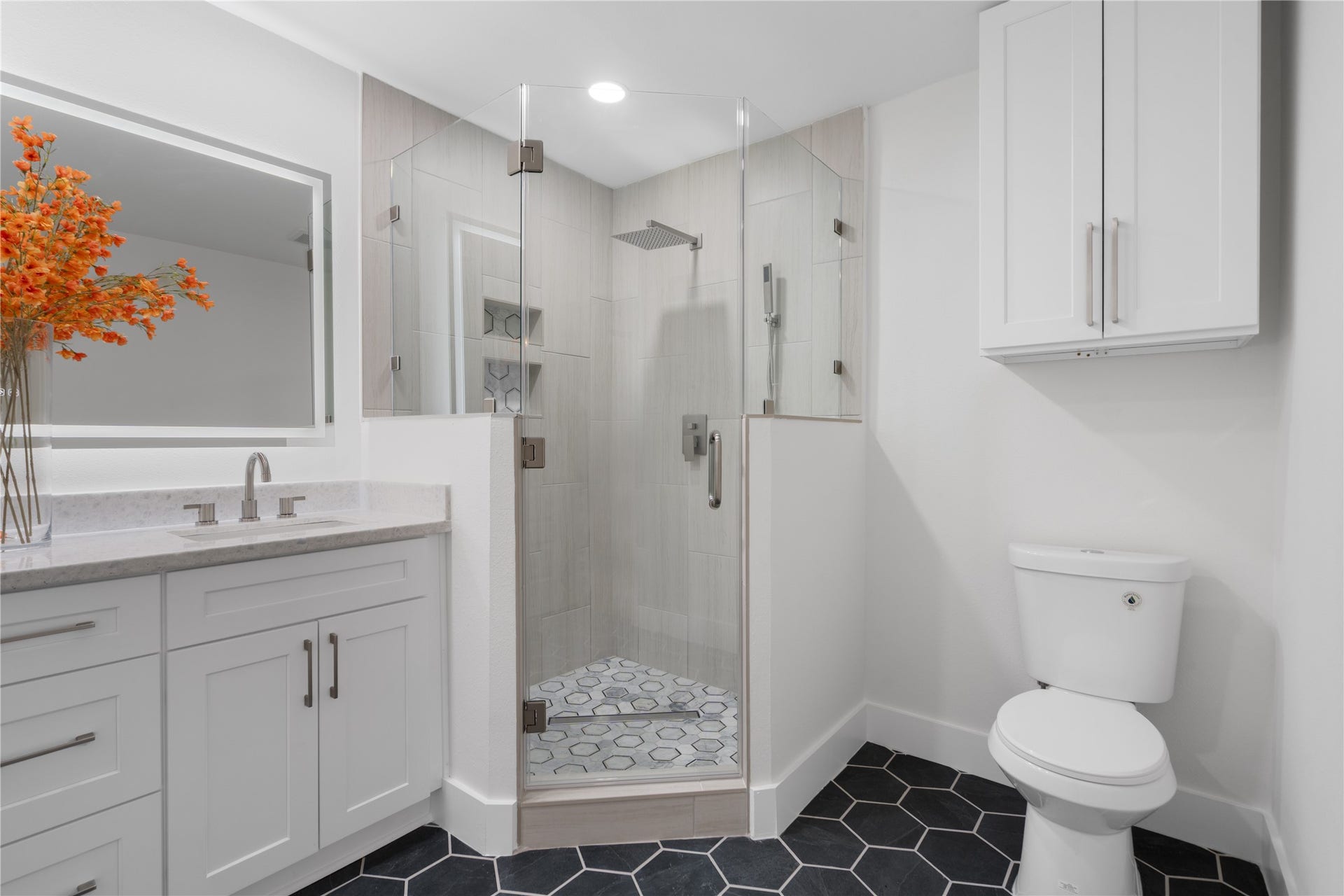 12019 Beth Lane, Magnolia, TX 77354 Primary Bath is stunning with all the details from the tiled hexagon flooring, to the rain shower hardware, lighting, custom shower glass door.