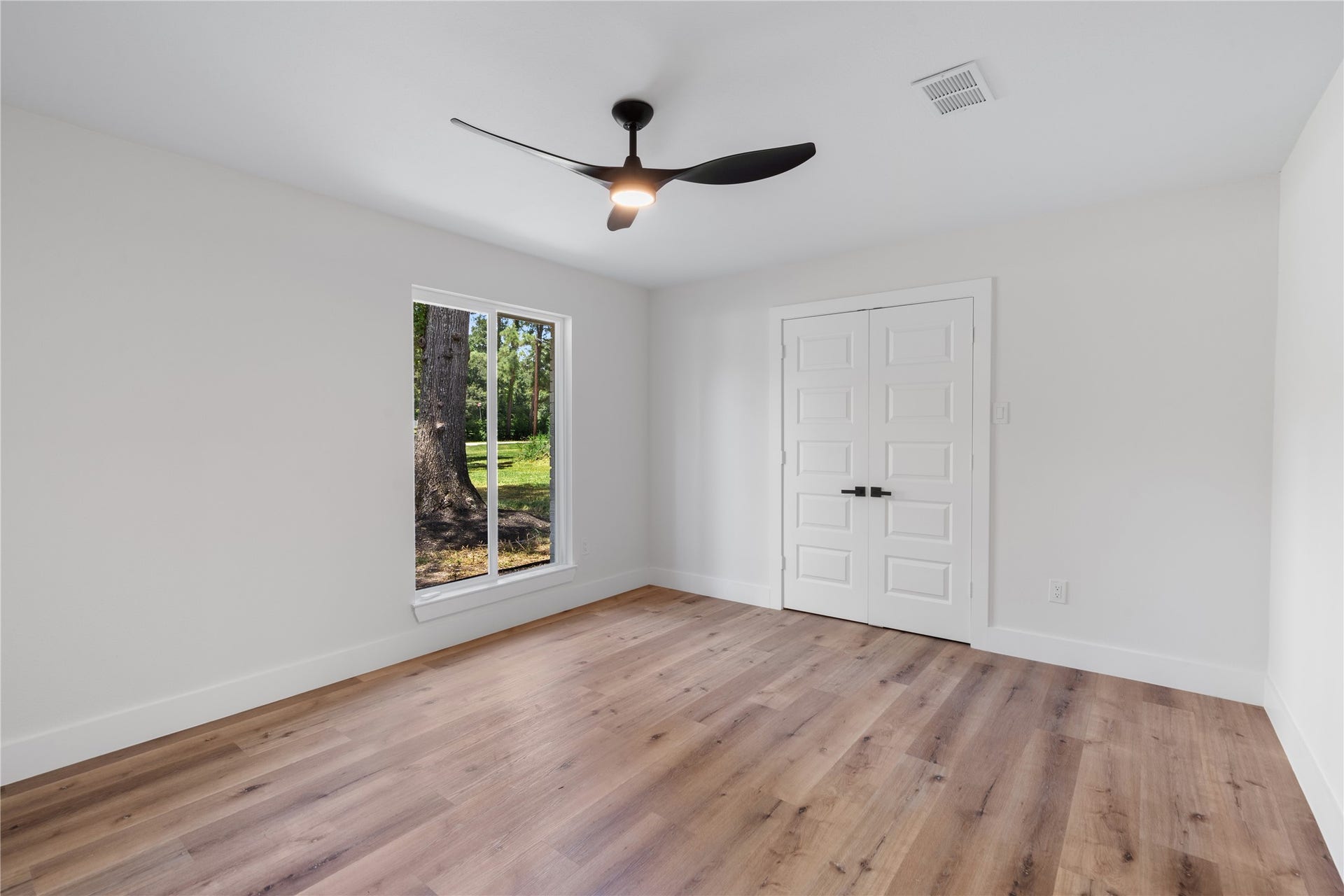 12019 Beth Lane, Magnolia, TX 77354 The Notable primary suite holds an oversized window inviting in lots of natural light, a large walk-in closet behind the double doors. Dressed in clean and modern details from the 5" baseboards, to the modern panel doors, and 3 blade fan with led lighting.