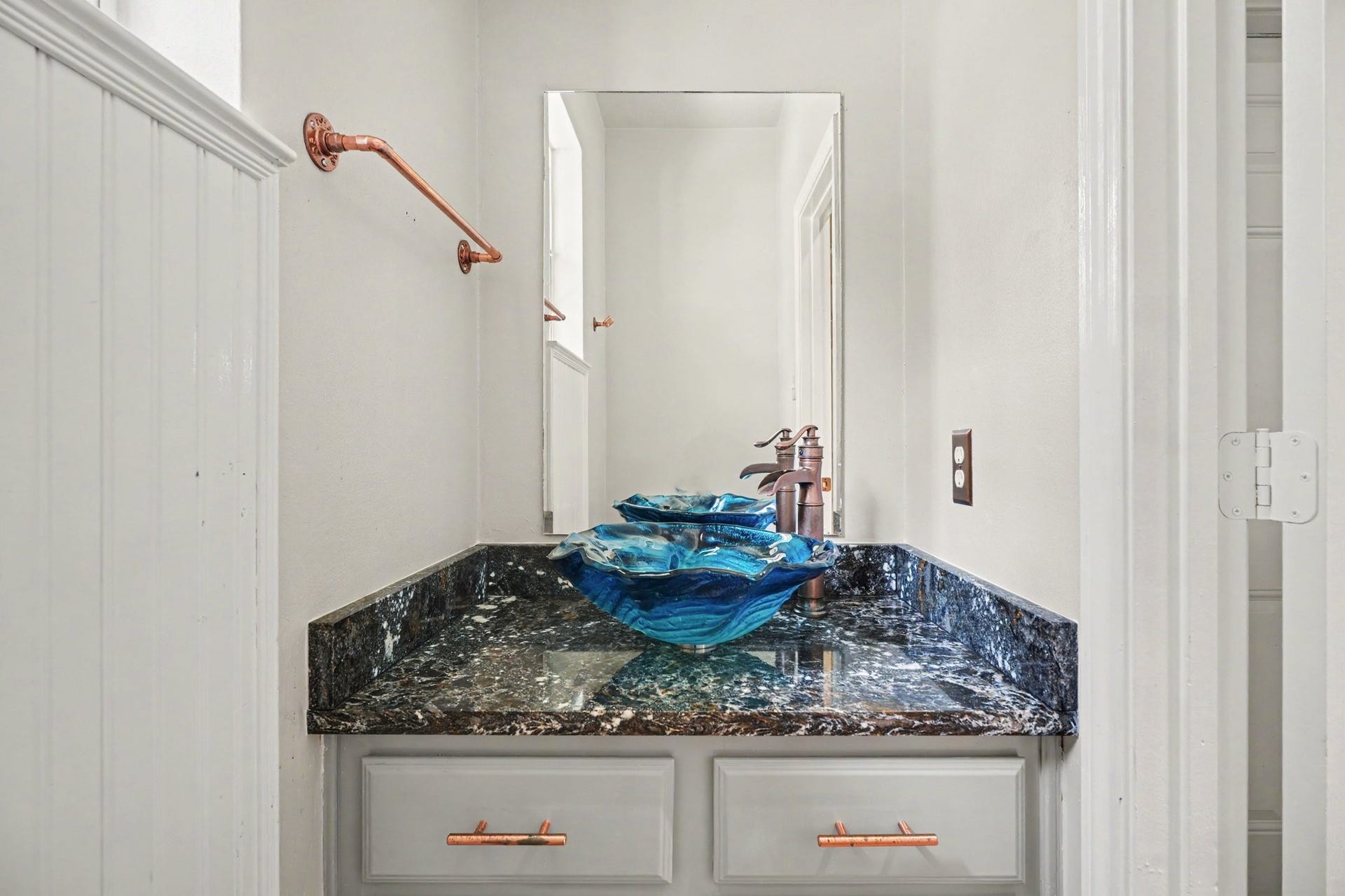 16507 Heather Meadow Court, Pasadena, TX 77059 Half bathroom conveniently located off the kitchen, adjacent to the laundry closet and garage entrance. Features a custom designer bowl sink that complements the home's signature blue accent color scheme.