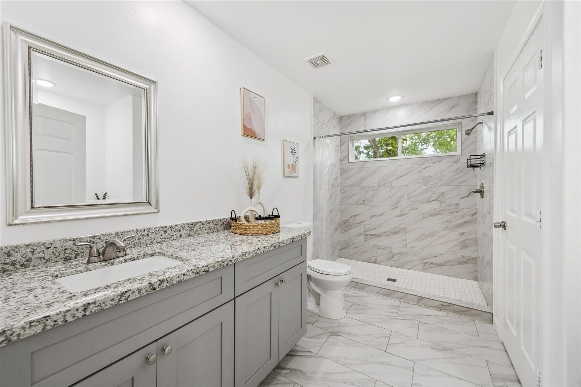 One of two dedicated vanities in the primary ensuite, offering ample storage, a wide granite countertop, and an undermount sinkperfect for everyday function and personal space.