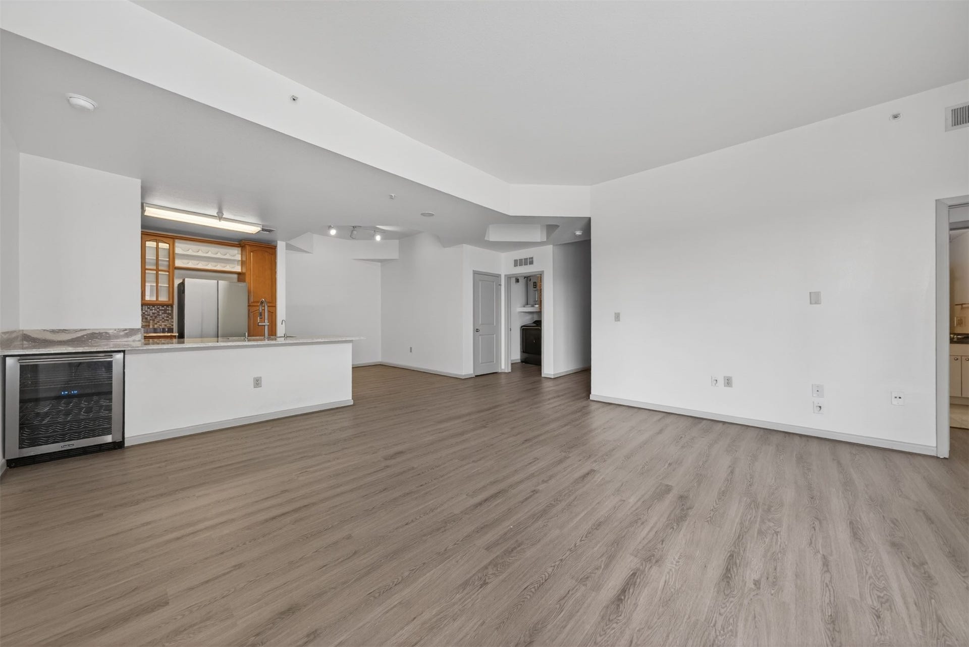 3505 Sage Road, #314, Houston, TX 77056 Spacious open-concept living area featuring modern luxury vinyl plank flooring, a sleek kitchen with stainless steel appliances, and ample natural light.