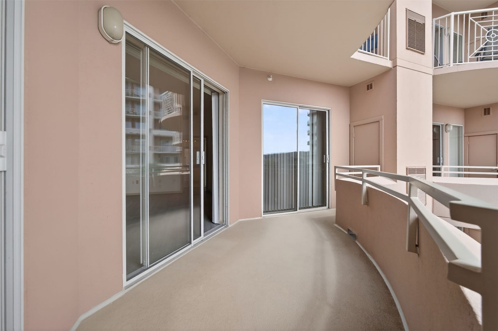 3505 Sage Road, #314, Houston, TX 77056 Spacious curved balcony with sliding glass doors and a modern railing, perfect for enjoying outdoor relaxation. The balcony also features two additional storage closets.