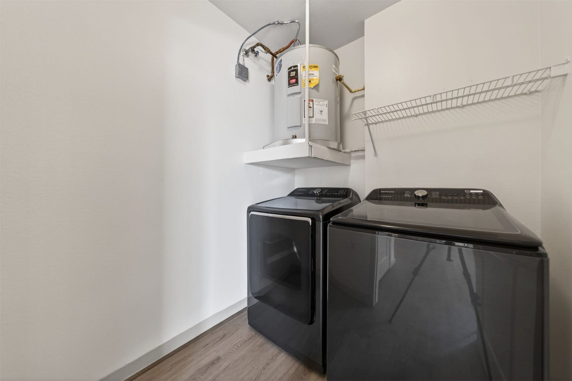 3505 Sage Road, #314, Houston, TX 77056 Modern laundry room with sleek appliances that are included, a water heater, and a convenient wire shelf for storage.