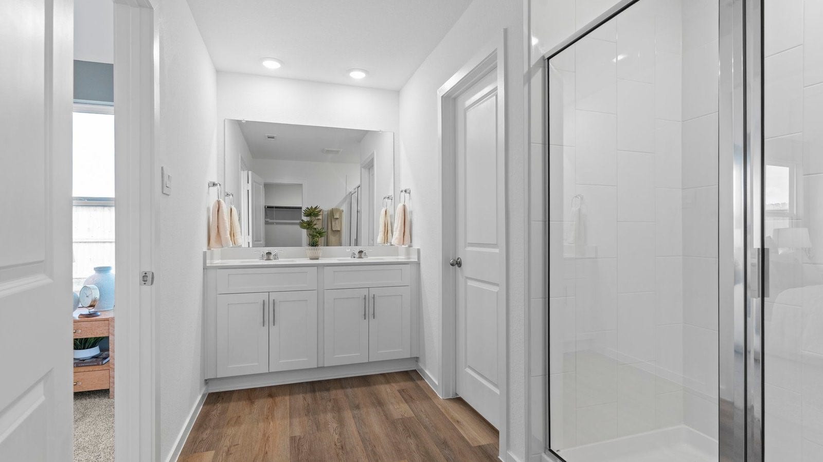 3505 Horseshoe Trail Road, League City, TX 77511 Modern primary bathroom with double vanities, quartz countertops, and a glass-enclosed shower with a walk-in closet.
