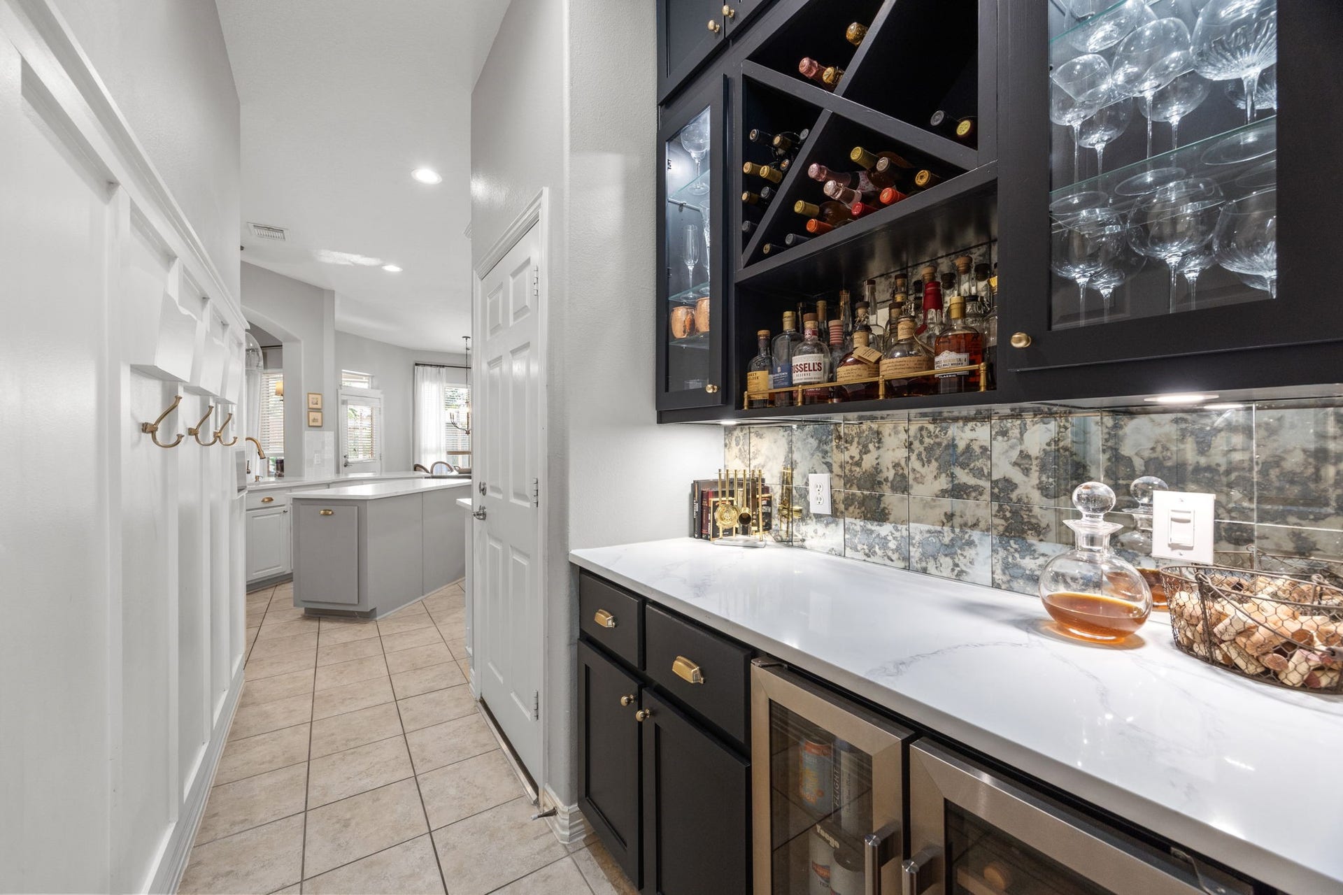 26823 Sandy Arbor Lane, Katy, TX 77494 A dedicated beverage bar adds another entertaining space with custom cabinetry, wine storage, glass-front display cabinets, beverage refrigeration, updated countertop and a distinctive tiled backsplash.