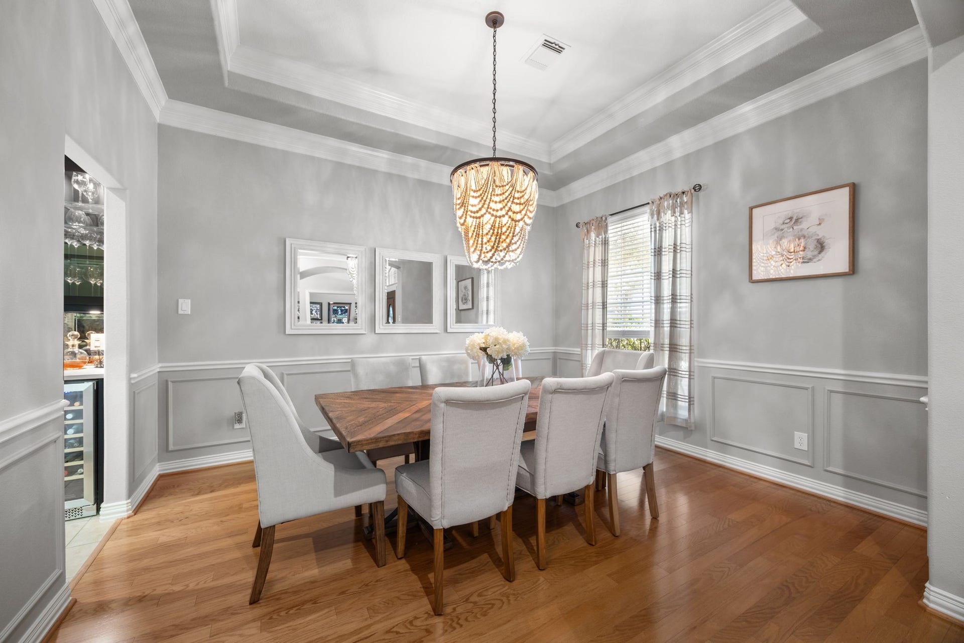 26823 Sandy Arbor Lane, Katy, TX 77494 Formal dining room features hardwood flooring, wainscoting, extensive crown molding, a tray ceiling and dramatic statement chandelier.