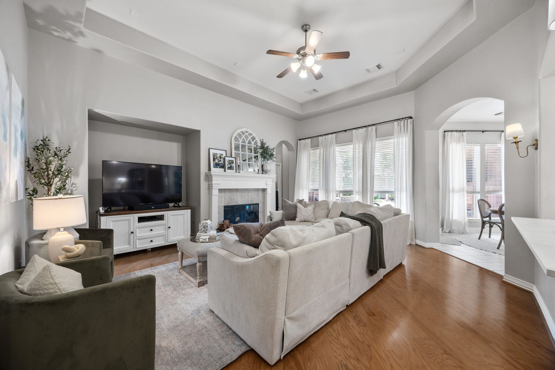 26823 Sandy Arbor Lane, Katy, TX 77494 Spacious family room offers hardwood flooring, a high tray ceiling, fireplace with detailed mantel and a wall of windows, with easy access to the kitchen and adjoining breakfast area.