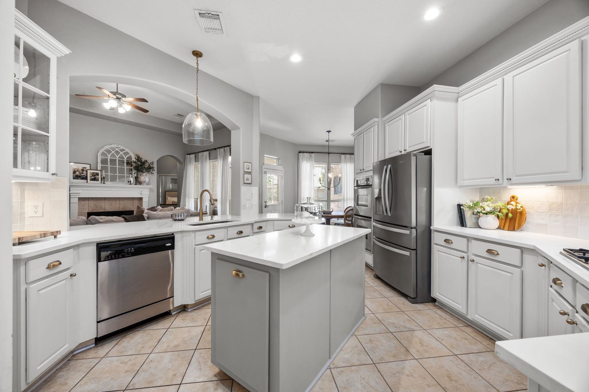 26823 Sandy Arbor Lane, Katy, TX 77494 Updated kitchen features crisp white cabinetry, contrasting center island, quartz countertops, warm gold hardware, stainless appliances and generous workspace, all arranged for both everyday function and entertaining.