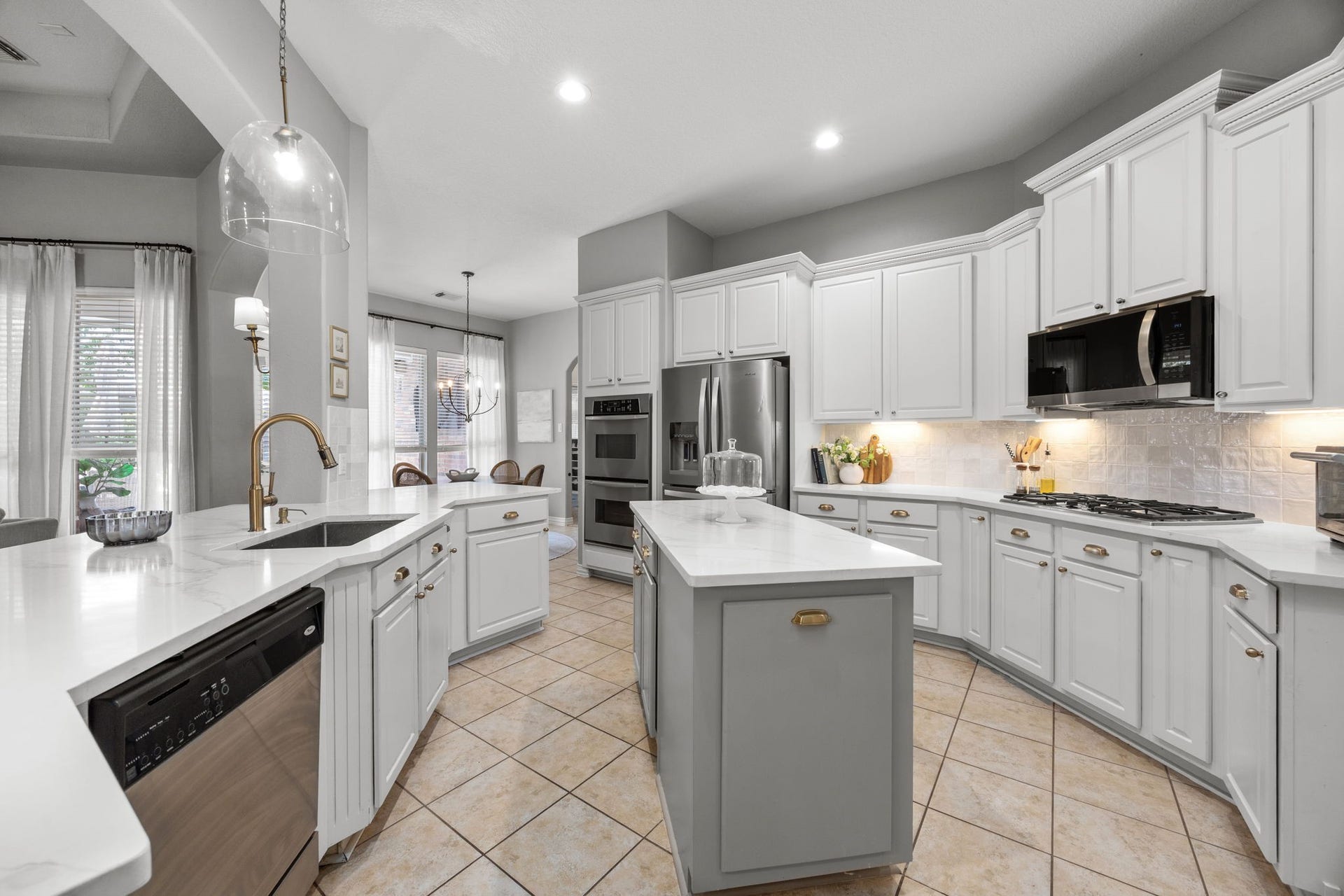 26823 Sandy Arbor Lane, Katy, TX 77494 A contrasting center island anchors the kitchen, complemented by white cabinetry with under-cabinet lighting. Highlights include a gas cooktop with built-in microwave and double ovens .