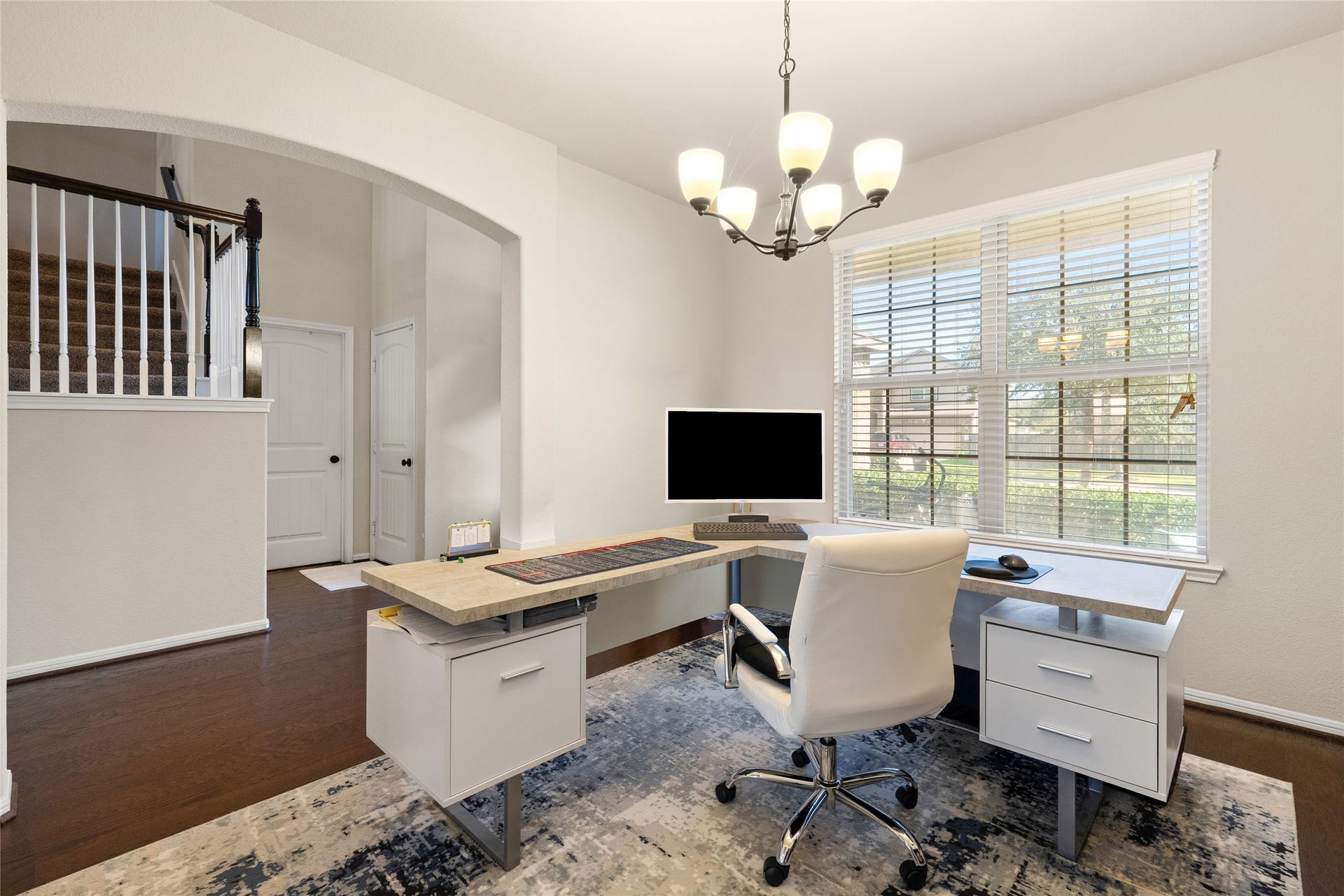 3650 Daintree Park Drive, Katy, TX 77494 Bright and inviting home office featuring sleek modern furniture, a large window for natural light, and elegant lighting fixtures, perfect for productivity and comfort.