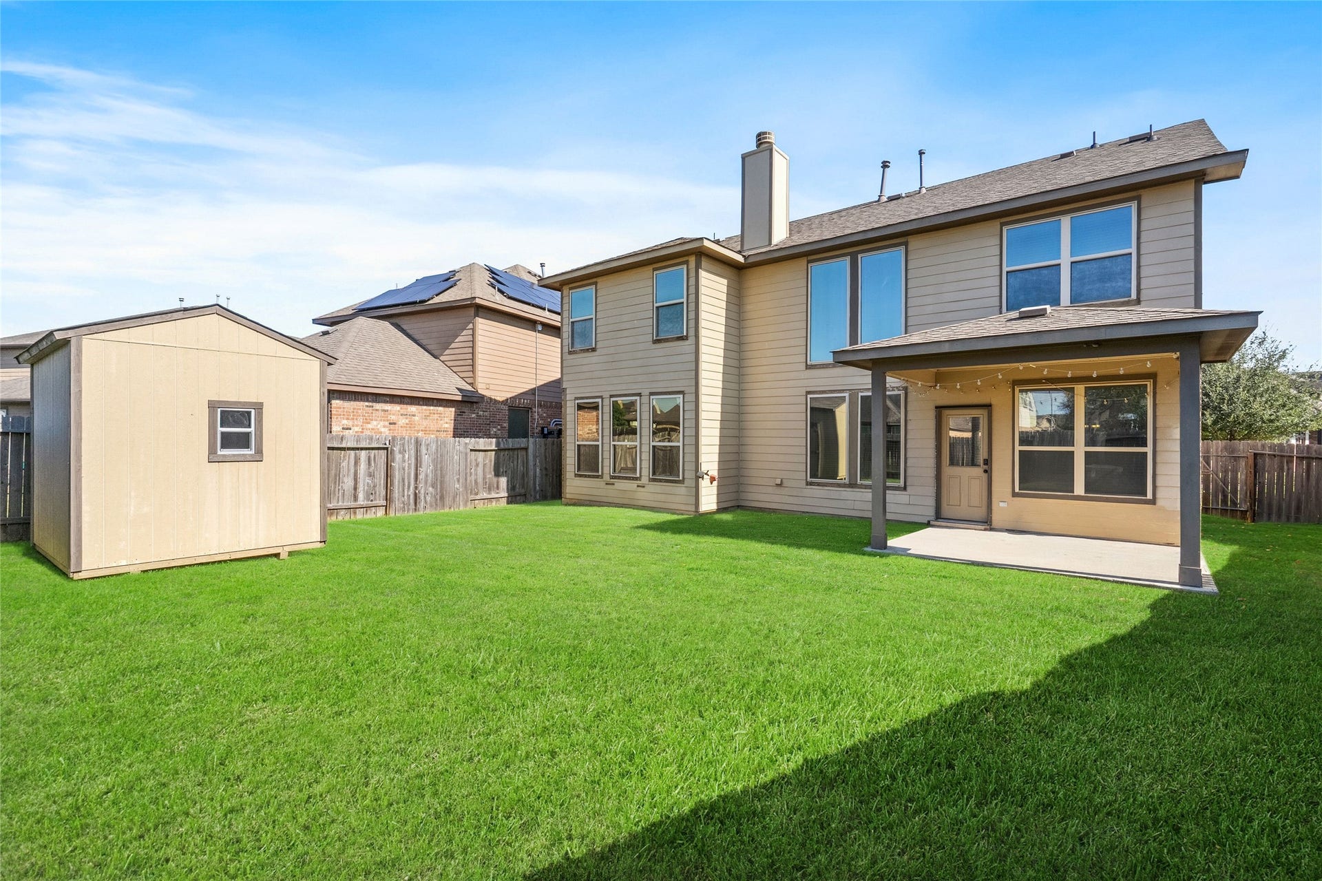 3650 Daintree Park Drive, Katy, TX 77494 Spacious backyard featuring a well-maintained lawn, a convenient storage shed, and a covered patio perfect for outdoor gatherings.