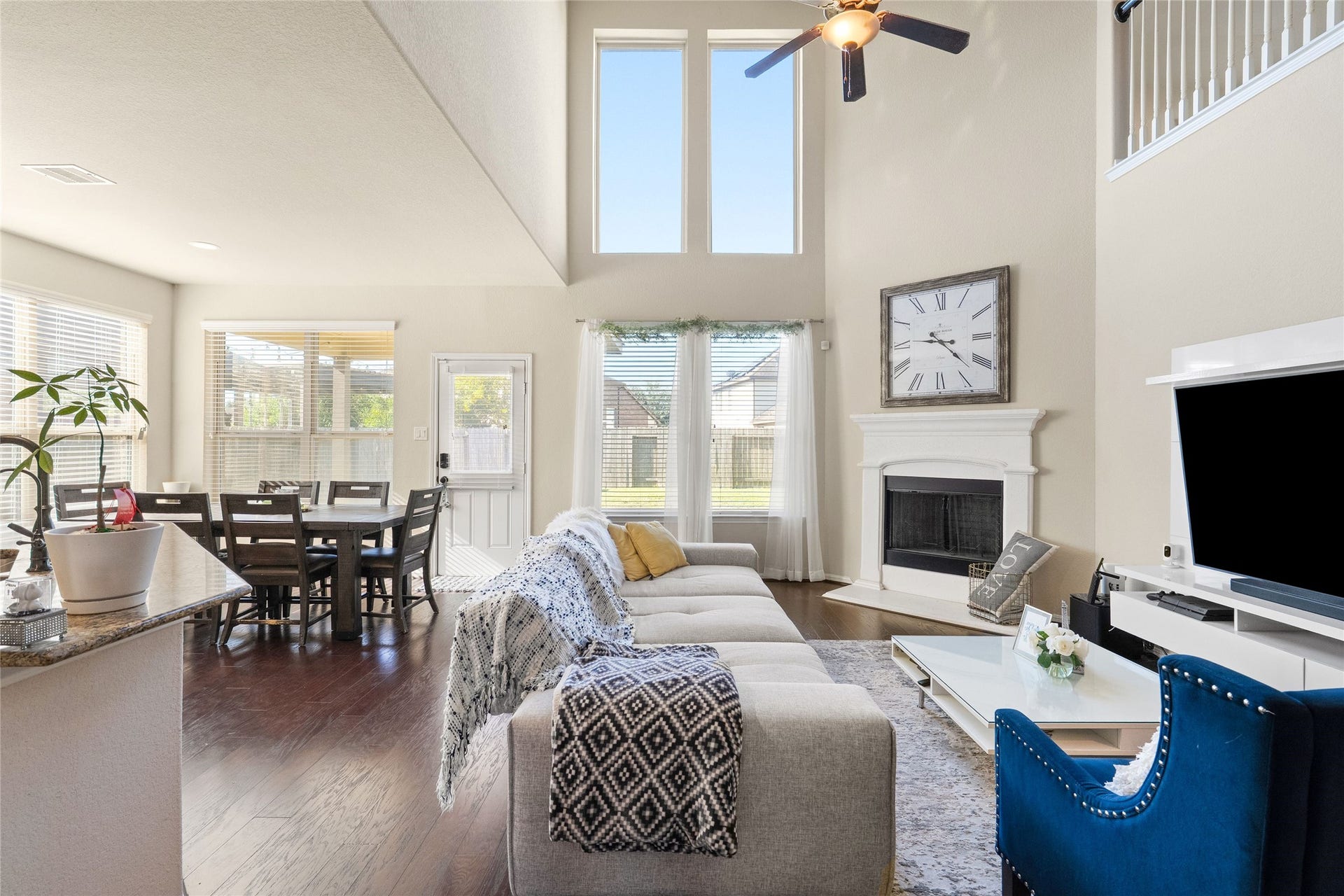 3650 Daintree Park Drive, Katy, TX 77494 Bright and inviting living area with vaulted ceilings, large windows, and a cozy fireplace. The open layout seamlessly connects to a dining area, making it perfect for entertaining.