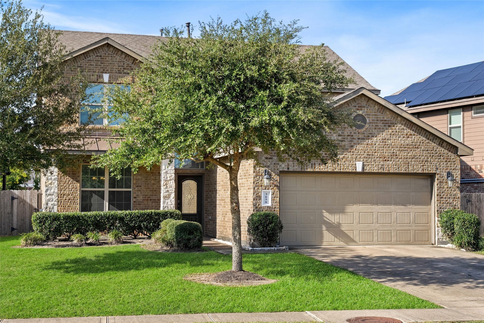 3650 Daintree Park Drive, Katy, TX 77494 Charming two-story brick home with a well-maintained front yard, mature tree, and spacious two-car garage.