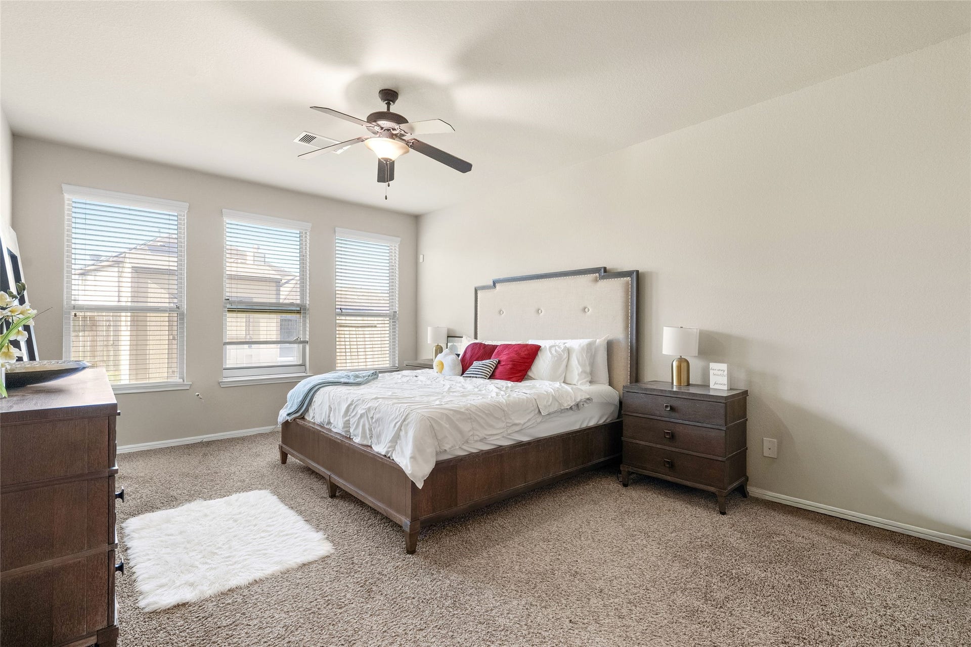 3650 Daintree Park Drive, Katy, TX 77494 Spacious bedroom with plush carpeting, abundant natural light from three large windows, and a stylish ceiling fan.