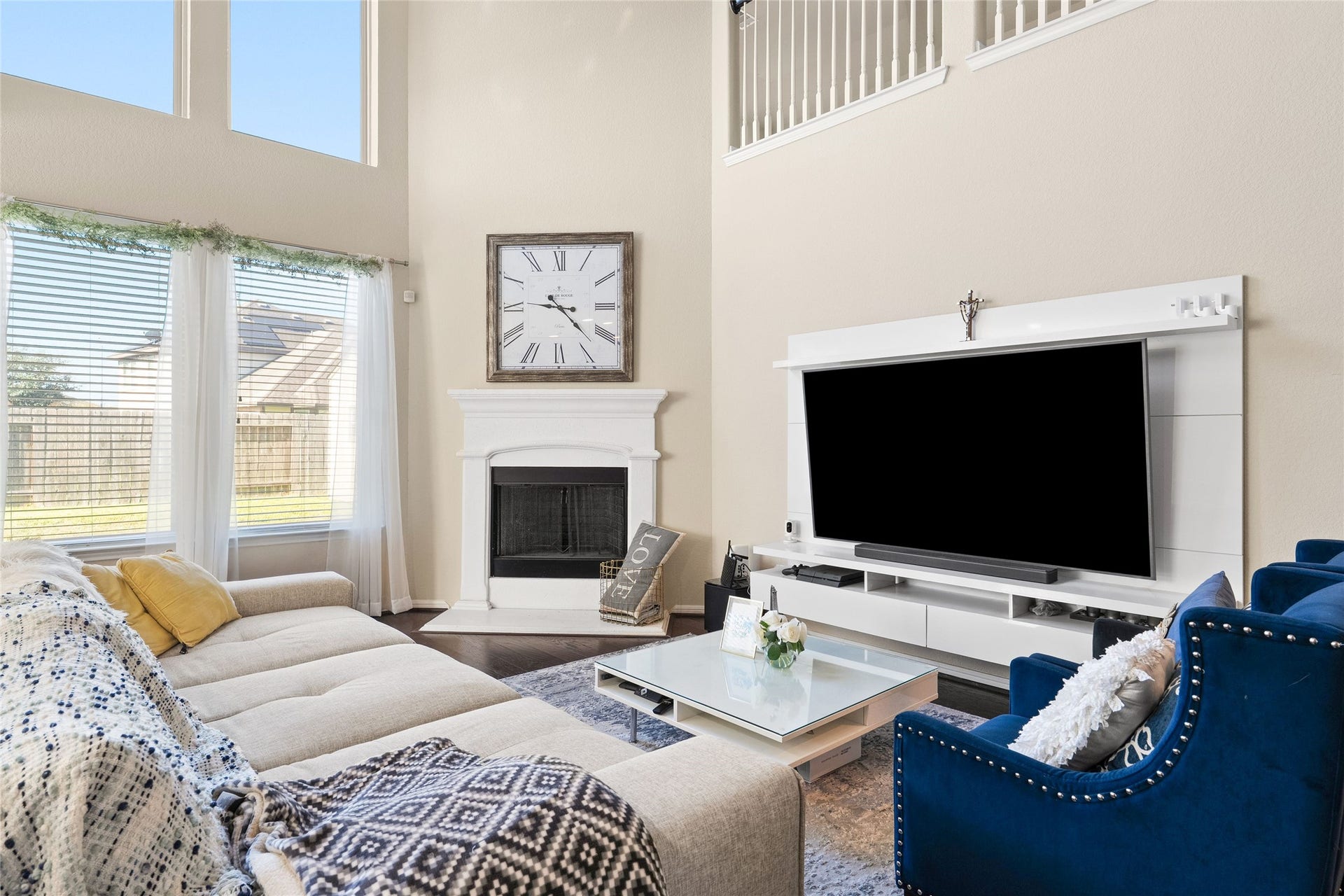 3650 Daintree Park Drive, Katy, TX 77494 Spacious living room with high ceilings, expansive windows, and plenty of natural light. Features a cozy fireplace, large TV, modern furnishings, and an elegant balcony overlook.
