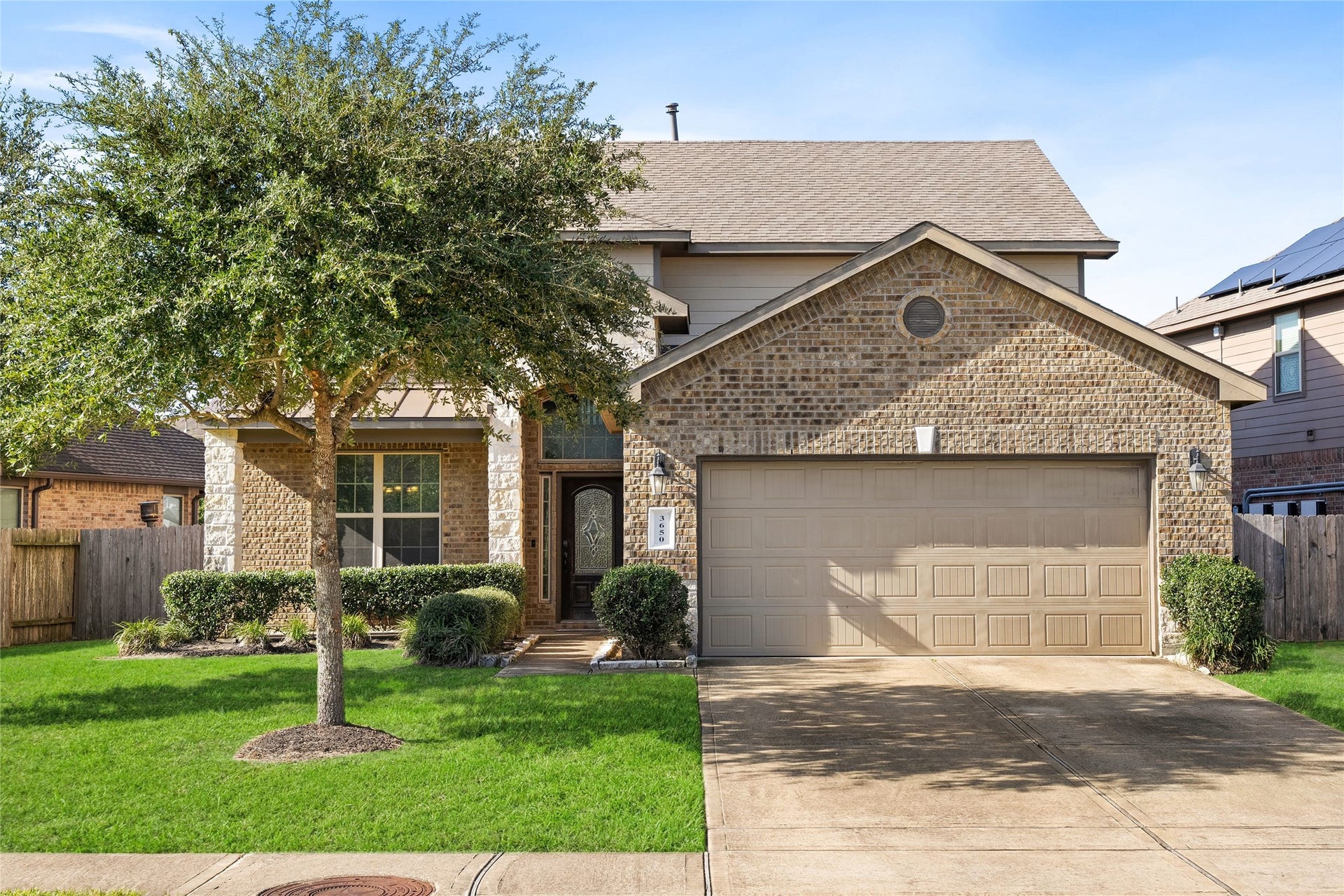 3650 Daintree Park Drive, Katy, TX 77494 Charming two-story home with a warm brick faade, inviting entryway, and well-maintained landscaping, featuring a spacious two-car garage and a mature tree providing shade.