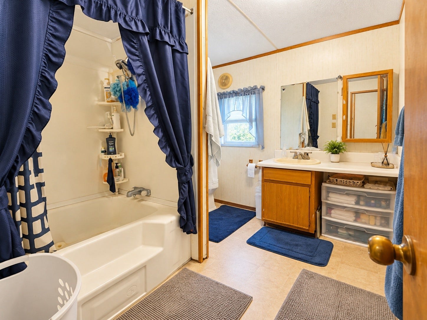 Virtually Edited  Secondary Bathroom: Full bathroom featuring a tub/shower combination, vanity with counter space, and a window providing natural light.