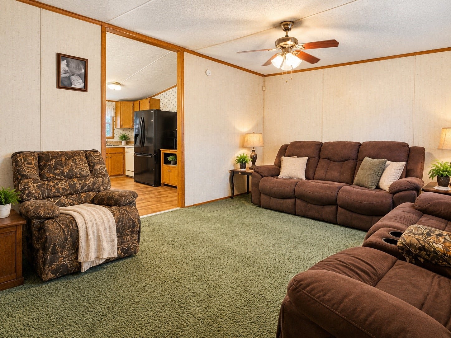 Virtually Edited  Living Room: Spacious living area featuring a ceiling fan, ample seating space, and convenient access to the kitchen.